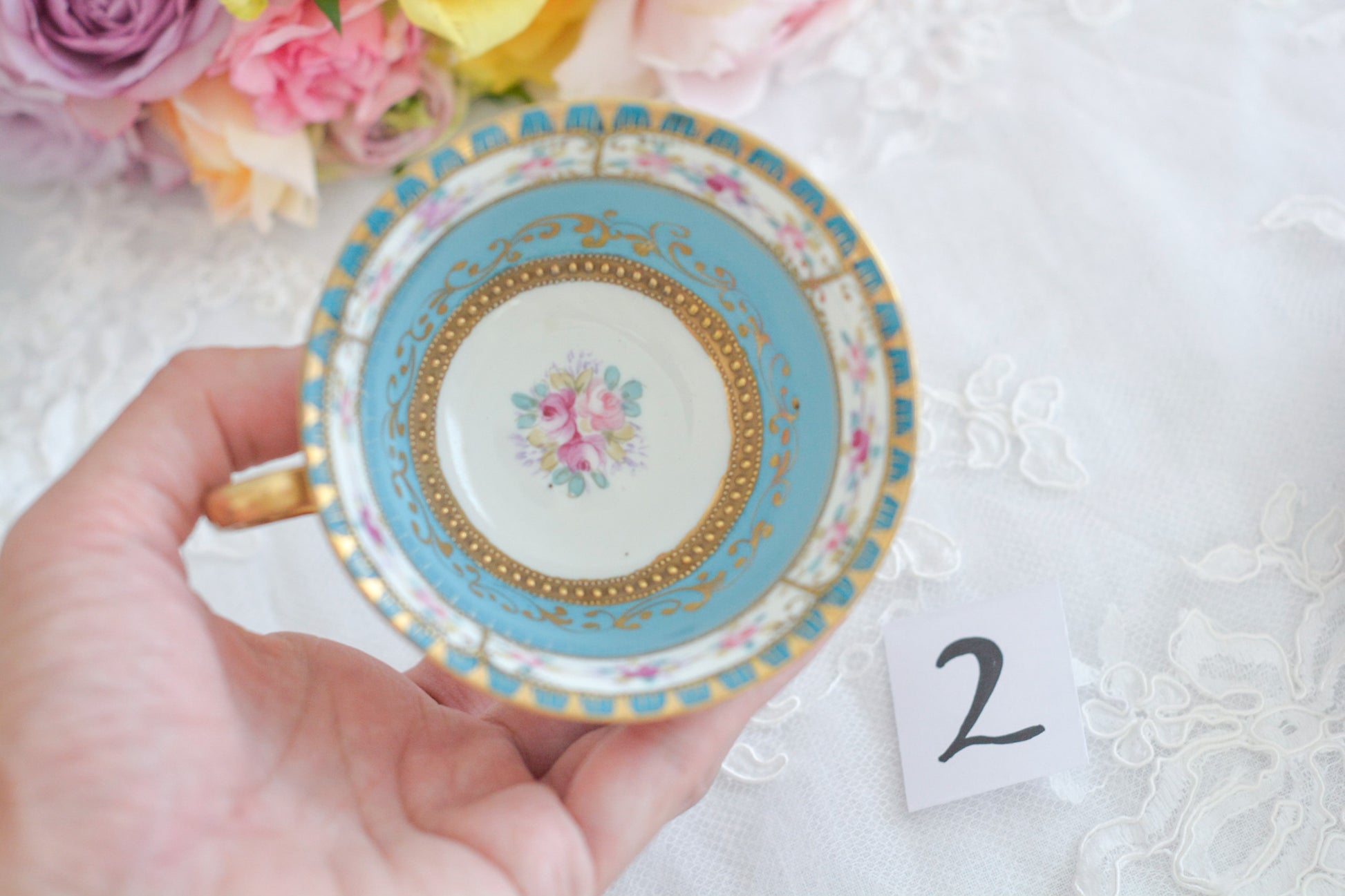 L&COという日本のメーカーのアンティーク里帰り品です。美しいターコイズブルーに金盛りの金彩、ハンドペイントで描かれた可憐なバラが上品なお品。1800年代後半頃からノリタケをはじめ日本からたくさんのメーカーが英国やアメリカに陶磁器を輸出していました。L&COは英国の老舗デパートリバティで販売されていたと言われています。キラキラしたティーセットがデパートに並べられている風景は、当時の人々の目と心を楽しませていたことでしょう。オールドニッポンの美しいティーカップでティータイムをお楽しみください。