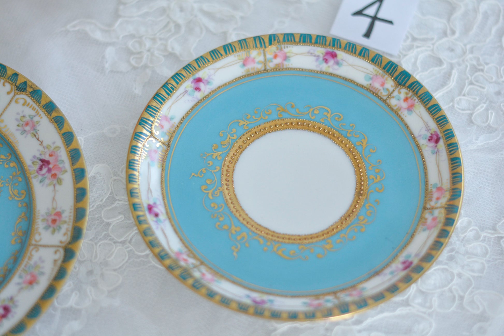 L&COという日本のメーカーのアンティーク里帰り品です。美しいターコイズブルーに金盛りの金彩、ハンドペイントで描かれた可憐なバラが上品なお品。1800年代後半頃からノリタケをはじめ日本からたくさんのメーカーが英国やアメリカに陶磁器を輸出していました。L&COは英国の老舗デパートリバティで販売されていたと言われています。キラキラしたティーセットがデパートに並べられている風景は、当時の人々の目と心を楽しませていたことでしょう。オールドニッポンの美しいティーカップでティータイムをお楽しみください。