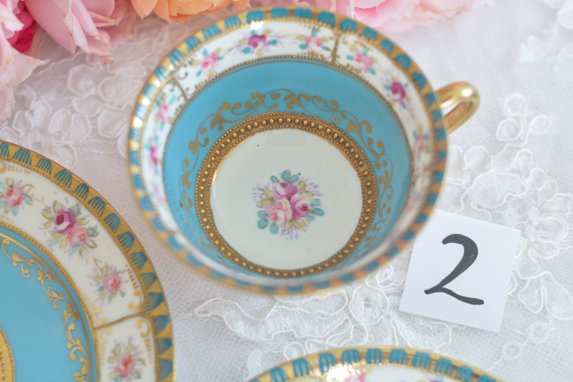 L&COという日本のメーカーのアンティーク里帰り品です。美しいターコイズブルーに金盛りの金彩、ハンドペイントで描かれた可憐なバラが上品なお品。1800年代後半頃からノリタケをはじめ日本からたくさんのメーカーが英国やアメリカに陶磁器を輸出していました。L&COは英国の老舗デパートリバティで販売されていたと言われています。キラキラしたティーセットがデパートに並べられている風景は、当時の人々の目と心を楽しませていたことでしょう。オールドニッポンの美しいティーカップでティータイムをお楽しみください。