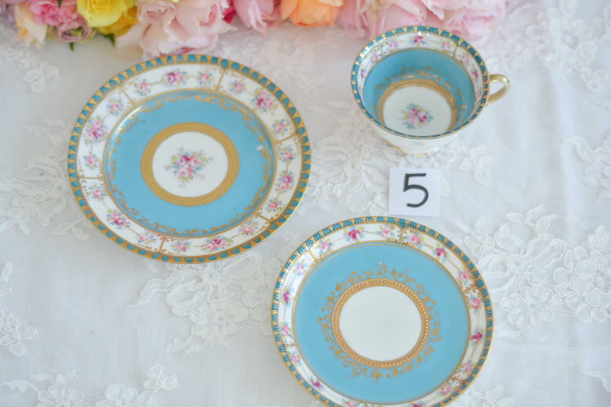 L&COという日本のメーカーのアンティーク里帰り品です。美しいターコイズブルーに金盛りの金彩、ハンドペイントで描かれた可憐なバラが上品なお品。1800年代後半頃からノリタケをはじめ日本からたくさんのメーカーが英国やアメリカに陶磁器を輸出していました。L&COは英国の老舗デパートリバティで販売されていたと言われています。キラキラしたティーセットがデパートに並べられている風景は、当時の人々の目と心を楽しませていたことでしょう。オールドニッポンの美しいティーカップでティータイムをお楽しみください。