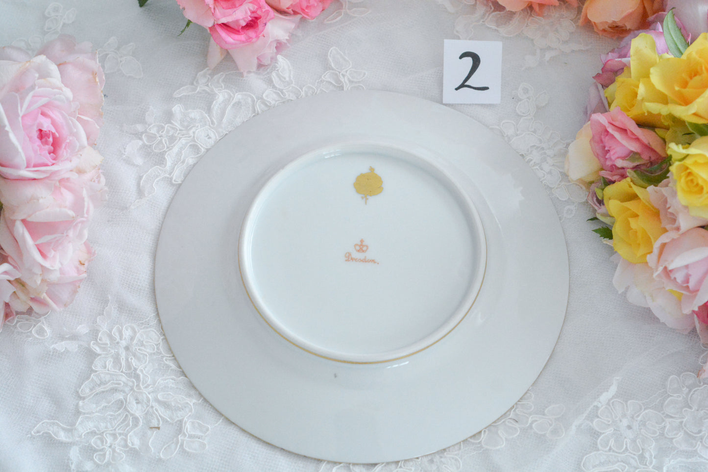 こちらのプレート達はドレスデンの工房で作られてはいますが、カール・ティーメ工房の作品ではありません。特に美しいので特集コーナーに入れさせていただきました。ハンドペイントで描かれた美しい花々に金彩の葉っぱの模様のような縁取りが豪華なお品。金盛りのドットがより花を添えています。キャビネットプレートとしても実際にお使いいただいても素敵なお品です。バックスタンプは1883年〜1893年頃に使われていた王冠マークで、いくつかの工房が集まって使用していました。バックスタンの上には金彩でお花が描かれています。