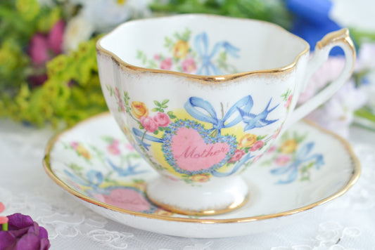 クイーンアンのとっても可愛らしいカップ&ソーサーです。リボンに勿忘草で縁取られたハート、ブルーバード。お母さん、ありがとうとLOVEの気持ちがたくさん詰まったようなとっても可愛らしいデザインです。なかなかも目にかかれないデザインで、母の日のプレゼントにもぴったりですね。