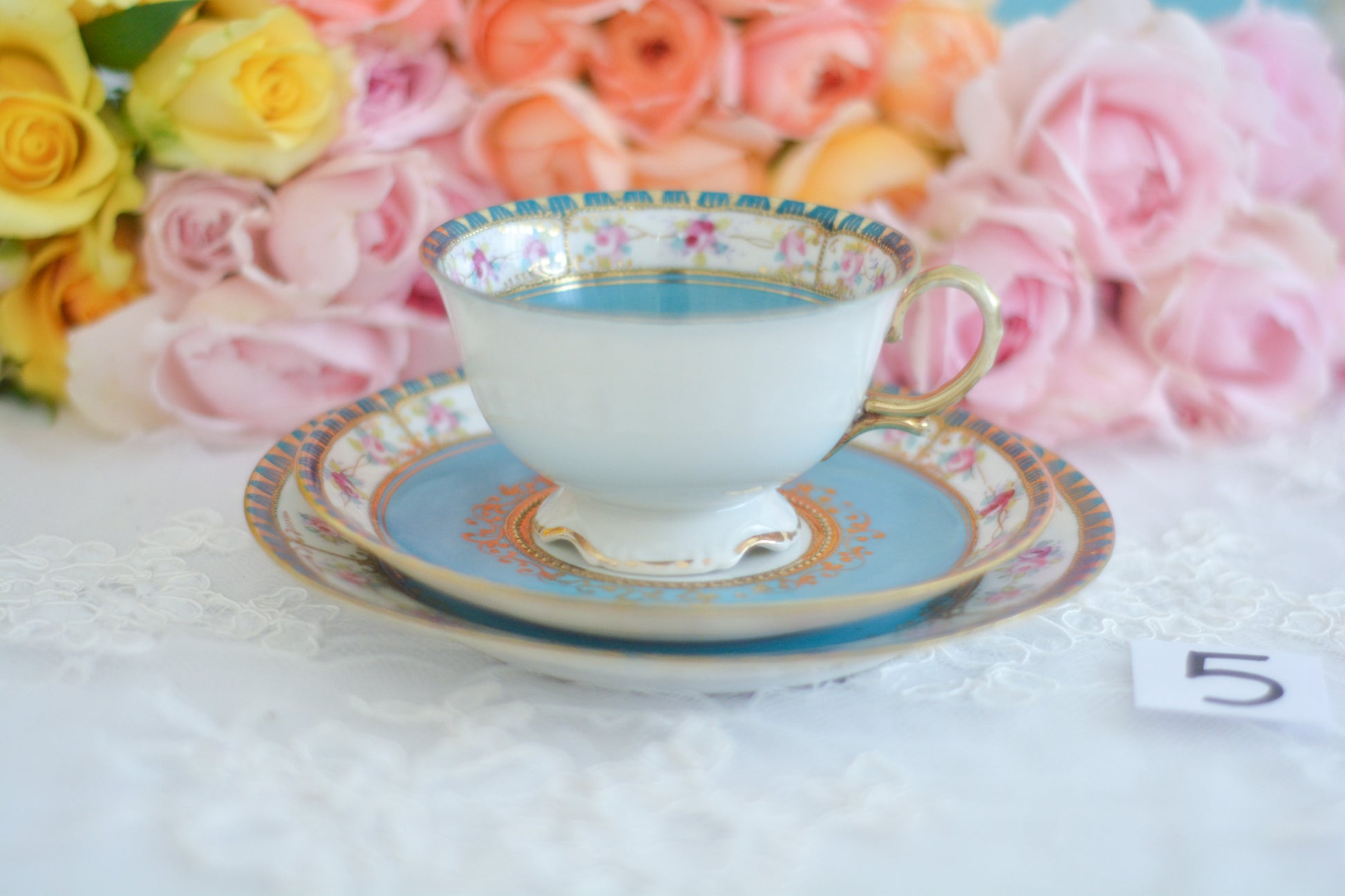 L&COという日本のメーカーのアンティーク里帰り品です。美しいターコイズブルーに金盛りの金彩、ハンドペイントで描かれた可憐なバラが上品なお品。1800年代後半頃からノリタケをはじめ日本からたくさんのメーカーが英国やアメリカに陶磁器を輸出していました。L&COは英国の老舗デパートリバティで販売されていたと言われています。キラキラしたティーセットがデパートに並べられている風景は、当時の人々の目と心を楽しませていたことでしょう。オールドニッポンの美しいティーカップでティータイムをお楽しみください。