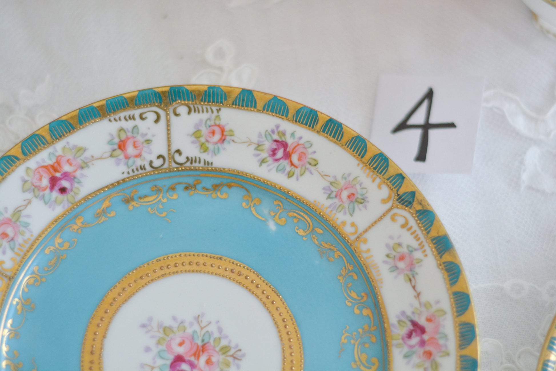 L&COという日本のメーカーのアンティーク里帰り品です。美しいターコイズブルーに金盛りの金彩、ハンドペイントで描かれた可憐なバラが上品なお品。1800年代後半頃からノリタケをはじめ日本からたくさんのメーカーが英国やアメリカに陶磁器を輸出していました。L&COは英国の老舗デパートリバティで販売されていたと言われています。キラキラしたティーセットがデパートに並べられている風景は、当時の人々の目と心を楽しませていたことでしょう。オールドニッポンの美しいティーカップでティータイムをお楽しみください。