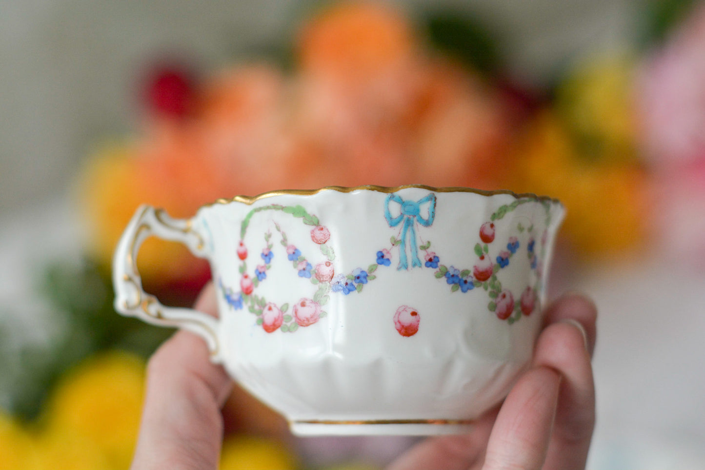 英国アンティーク、ハマースレイの貴重なハンドペイントのティートリオです。ブルーのリボンに薔薇と忘れな草のガーランドがとても可愛らしいです。