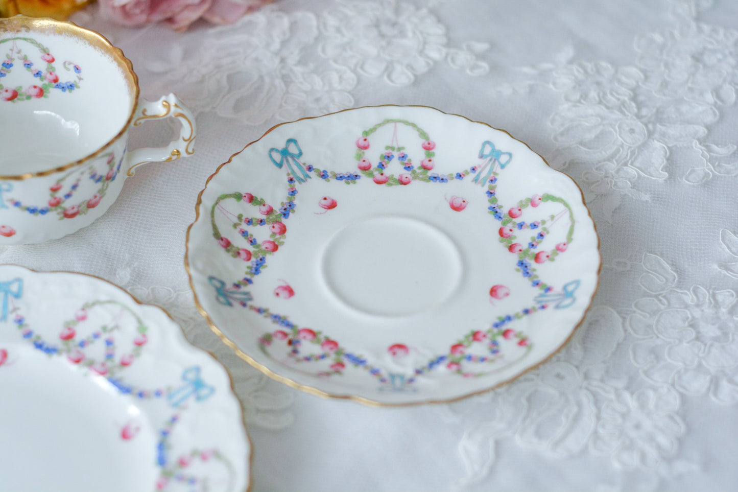 英国アンティーク、ハマースレイの貴重なハンドペイントのティートリオです。ブルーのリボンに薔薇と忘れな草のガーランドがとても可愛らしいです。