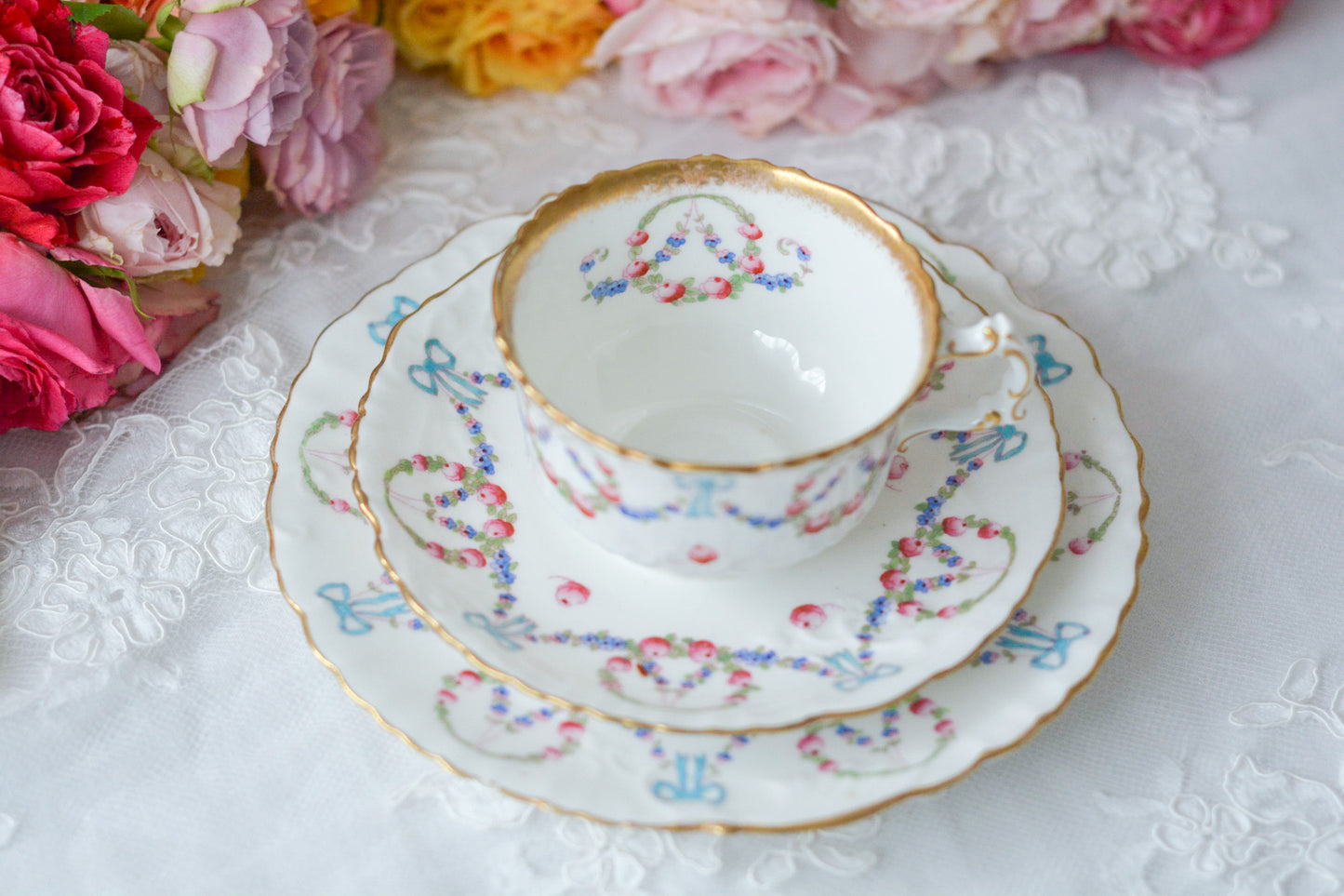 英国アンティーク、ハマースレイの貴重なハンドペイントのティートリオです。ブルーのリボンに薔薇と忘れな草のガーランドがとても可愛らしいです。