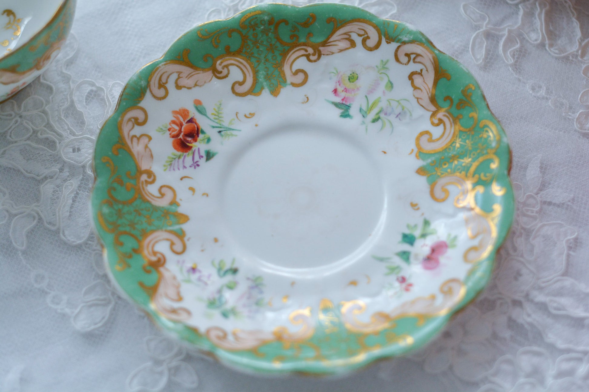 リッジウェイのFoliage Shapeのカップ&ソーサー。可愛らしいハンドルにハンドペイントで描かれた花々が描かれています。19世紀に作られた貴重なアンティークカップです。