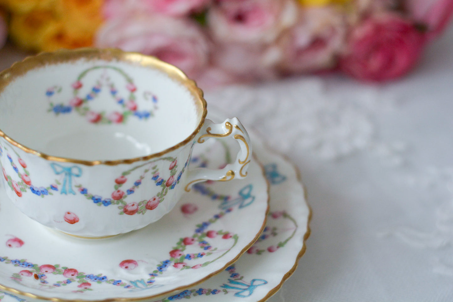 英国アンティーク、ハマースレイの貴重なハンドペイントのティートリオです。ブルーのリボンに薔薇と忘れな草のガーランドがとても可愛らしいです。