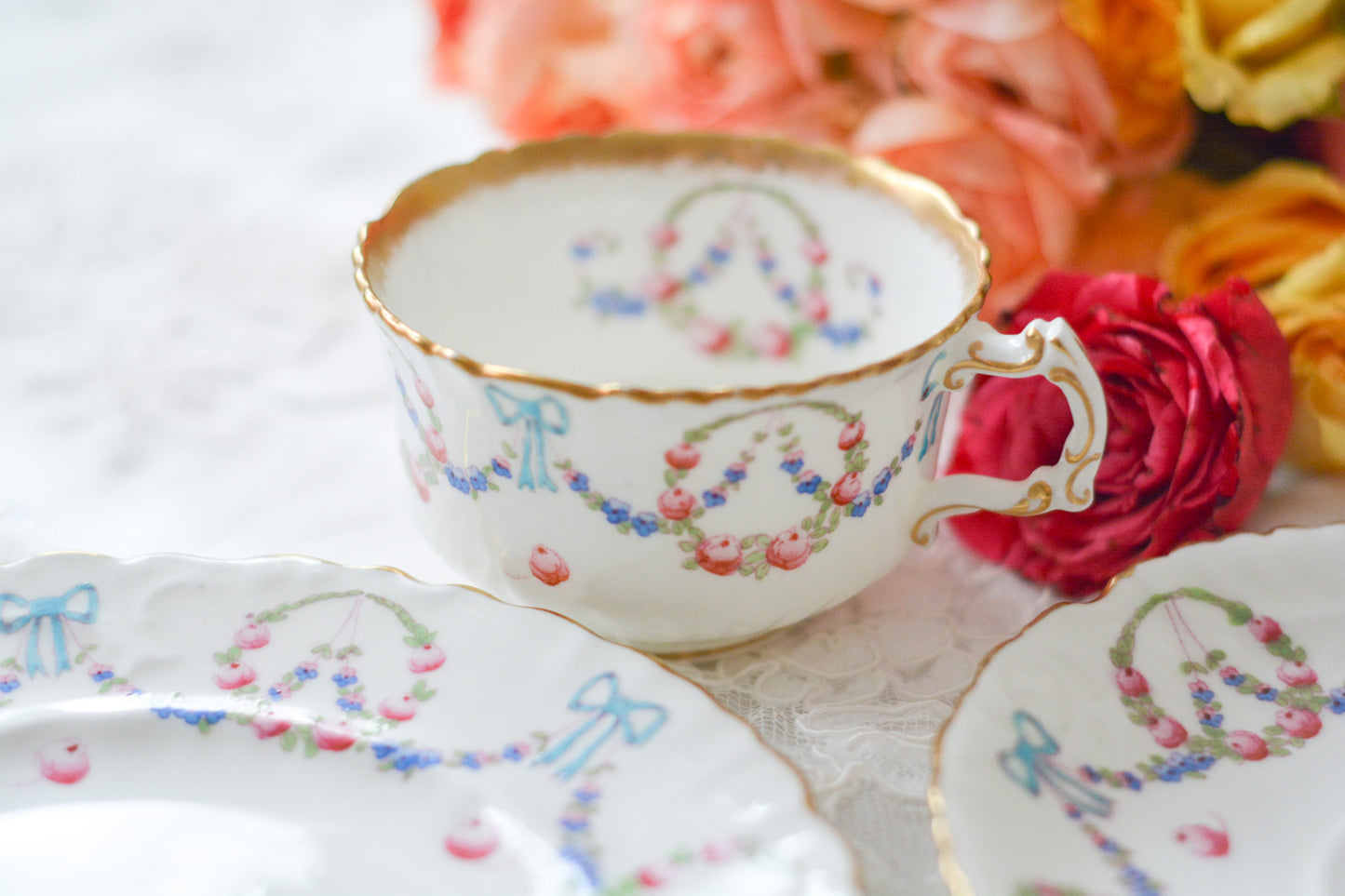 英国アンティーク、ハマースレイの貴重なハンドペイントのティートリオです。ブルーのリボンに薔薇と忘れな草のガーランドがとても可愛らしいです。