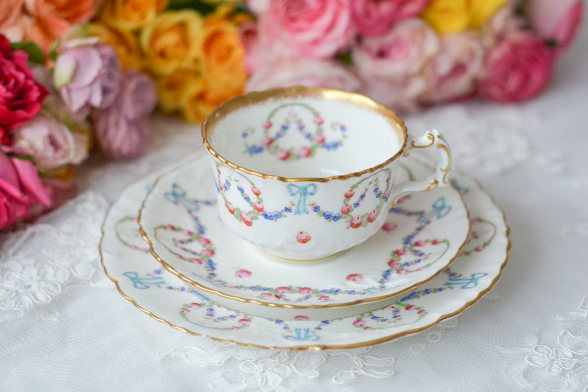 英国アンティーク、ハマースレイの貴重なハンドペイントのティートリオです。ブルーのリボンに薔薇と忘れな草のガーランドがとても可愛らしいです。