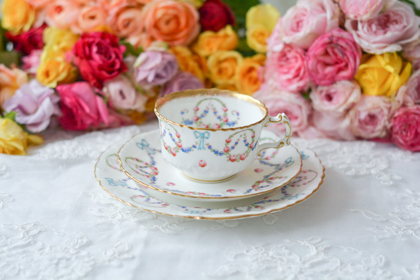 英国アンティーク、ハマースレイの貴重なハンドペイントのティートリオです。ブルーのリボンに薔薇と忘れな草のガーランドがとても可愛らしいです。