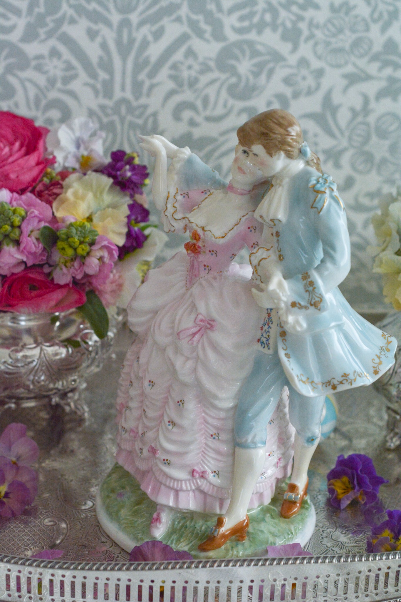ロイヤルウースターの「AGE OF CORTSHIP」シリーズの「The Flirtation」というフィギュリンです。「The Flirtation」「The Tryst」「The Betrothal」「The Proposal」があり、シリーズ名の通り、男女ペアのフィギュリンで構成されています。 寄り添ってダンスしているようにも見えます。 そしてパステルカラーの衣装の雰囲気やお顔の表情も柔らかく、初々しい様子も伝わってきます。2500体しか製造されていない大変貴重なフィギュリンです。