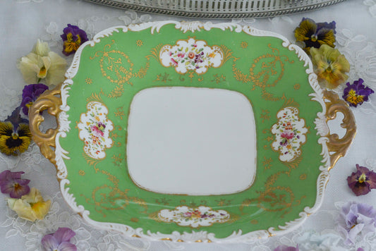 コールポートのアップルグリーンカラーが美しいB&Bプレート。スクロール模様の縁取りに金彩のガーランド、窓枠の中には可憐な花々が描かれています。繊細で優美なデザインはさすがコールポート!ですね。ハンドル付きのプレートで、使いやすく機能的なのも魅力的。ティータイムに活躍してくれます。