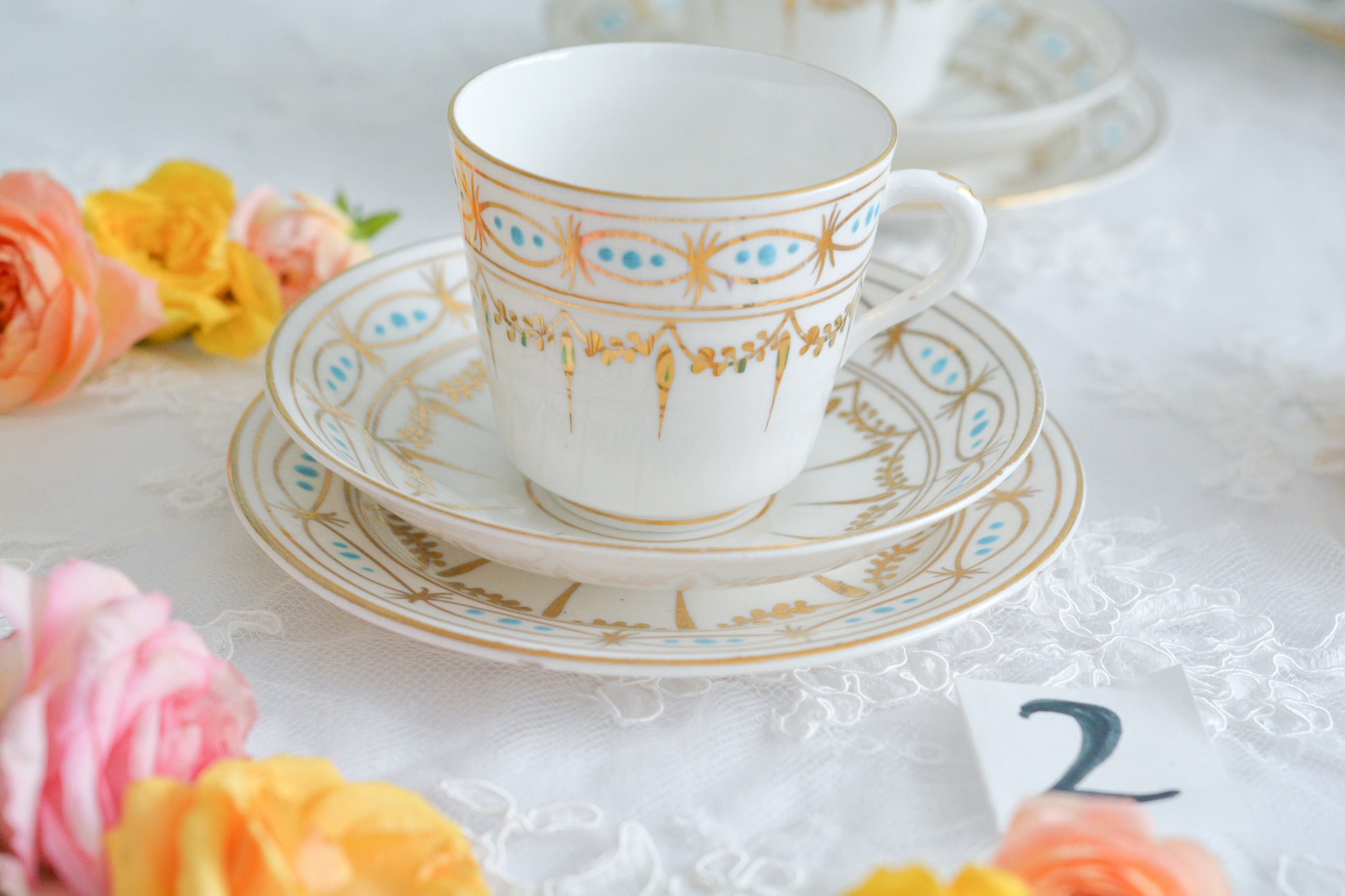 ハンドペイントで描かれた曲線美。アールヌーボースタイルのティートリオです。金彩にターコイズブルーのドットのコントラストが素敵なお品。カップは紅茶にもコーヒーにもお使いいただきやすいデザインです。