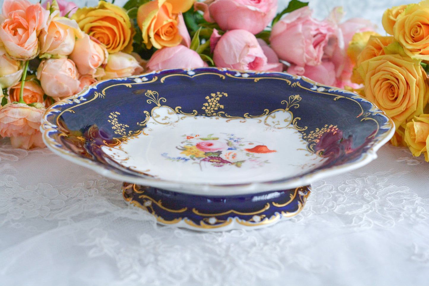 コバルトブルーカラーの美しいミントンのタッツァです。タッツァとはコンポートのような脚付きのプレートです。フルーツやお菓子を盛り付けるのにとても重宝するお品。美しいコバルトブルーカラーにハンドペイントのブーケがとても美しいです。あなたの大切なティータイムに是非お使いください