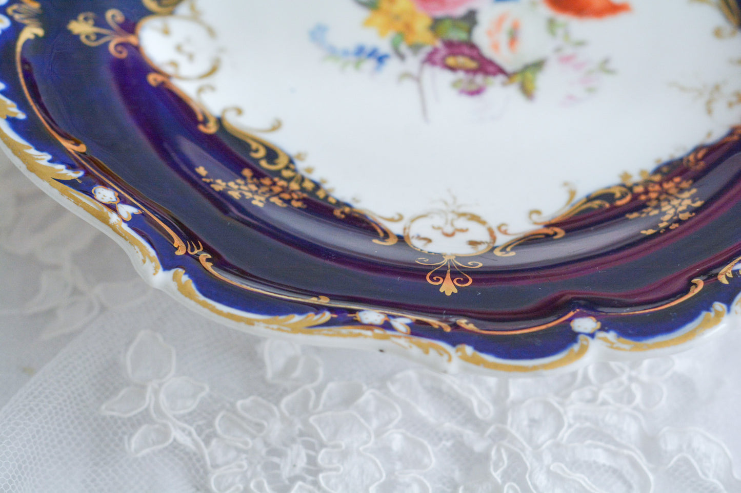 コバルトブルーカラーの美しいミントンのタッツァです。タッツァとはコンポートのような脚付きのプレートです。フルーツやお菓子を盛り付けるのにとても重宝するお品。美しいコバルトブルーカラーにハンドペイントのブーケがとても美しいです。あなたの大切なティータイムに是非お使いください