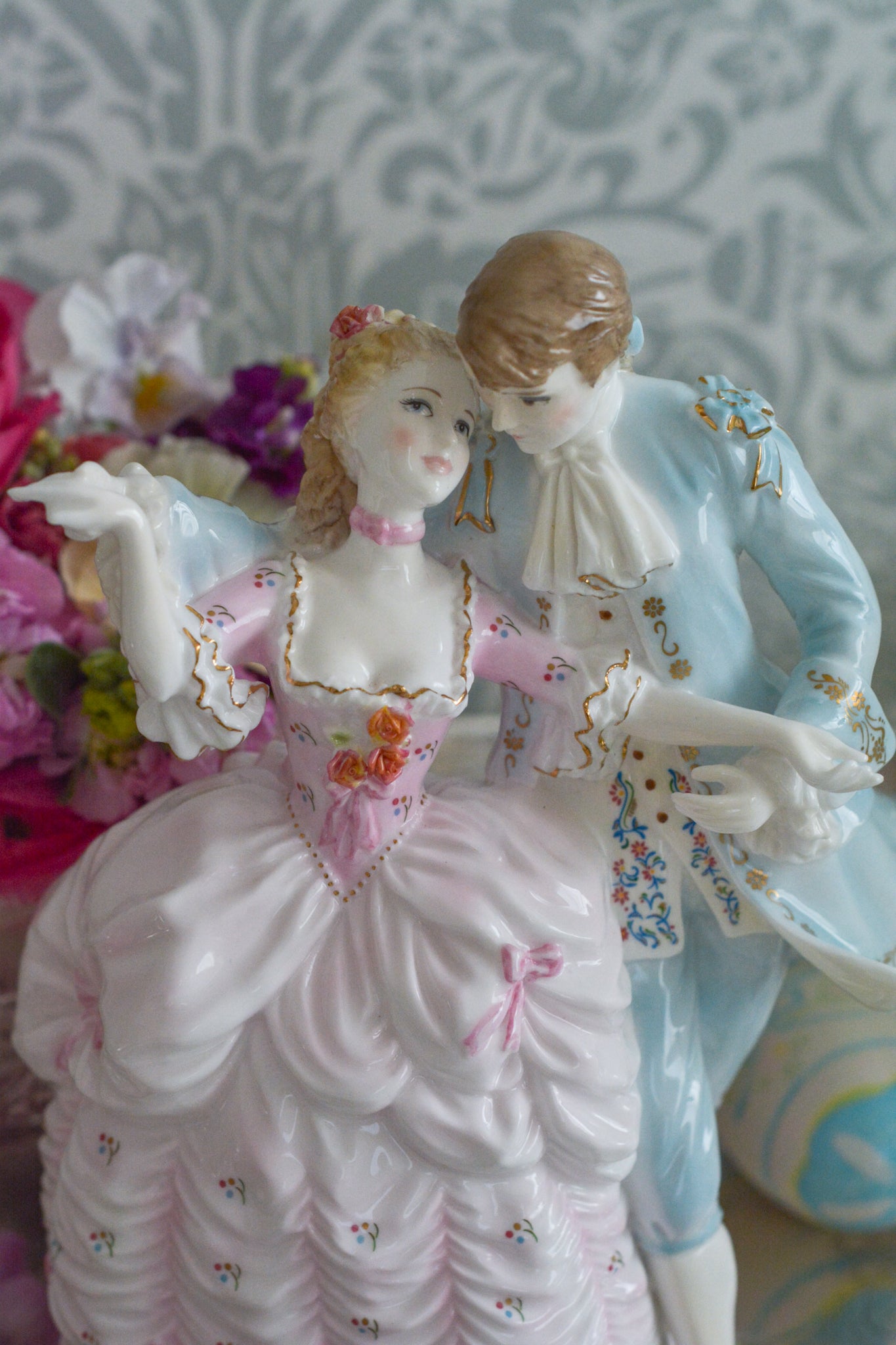 ロイヤルウースターの「AGE OF CORTSHIP」シリーズの「The Flirtation」というフィギュリンです。「The Flirtation」「The Tryst」「The Betrothal」「The Proposal」があり、シリーズ名の通り、男女ペアのフィギュリンで構成されています。 寄り添ってダンスしているようにも見えます。 そしてパステルカラーの衣装の雰囲気やお顔の表情も柔らかく、初々しい様子も伝わってきます。2500体しか製造されていない大変貴重なフィギュリンです。