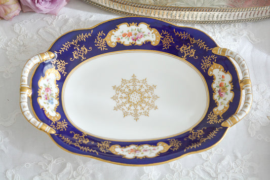 コールポートらしい上品なデザインの持ち手付きのプレート。オーバル形でお菓子やサンドイッチ、フルーツなどを盛り付けるのに使いやすいデザインです。可憐な花々に、金盛りの金彩がコバルトブルーカラーによく映えてとても美しいプレートです。