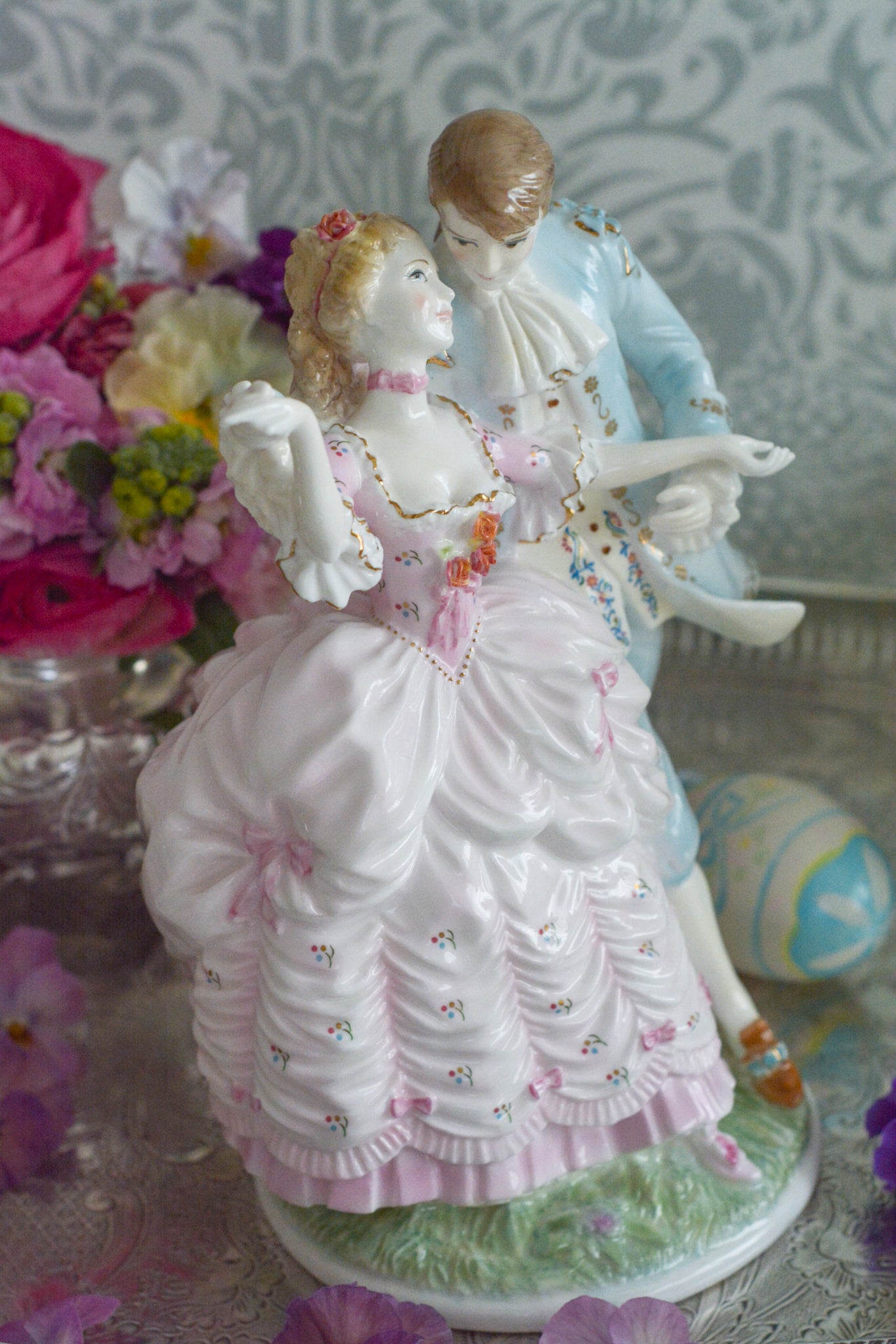 ロイヤルウースターの「AGE  OF CORTSHIP」シリーズの「The Flirtation」というフィギュリンです。「The Flirtation」「The Tryst」「The Betrothal」「The Proposal」があり、シリーズ名の通り、男女ペアのフィギュリンで構成されています。 寄り添ってダンスしているようにも見えます。 そしてパステルカラーの衣装の雰囲気やお顔の表情も柔らかく、初々しい様子も伝わってきます。2500体しか製造されていない大変貴重なフィギュリンです。