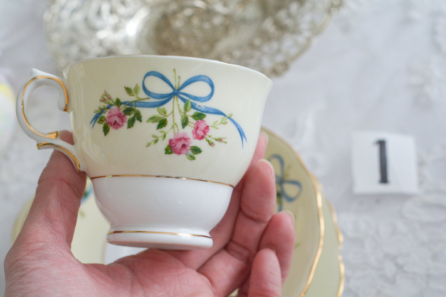 コルクラフ(Colclough)の可愛らしいティートリオ。コルクラフは1890年にハーバード・ジョセフ・コルクラフ氏が創業したメーカで、1940年代頃まで続いていました。コルクラフの中でもこのリボンの絵柄は人気で入手困難なお品です。クリーム色にブルーリボンと小さなバラの模様がとっても可愛らしいデザインです。パステルカラーがイースターや春のティータイムにもぴったりですね!