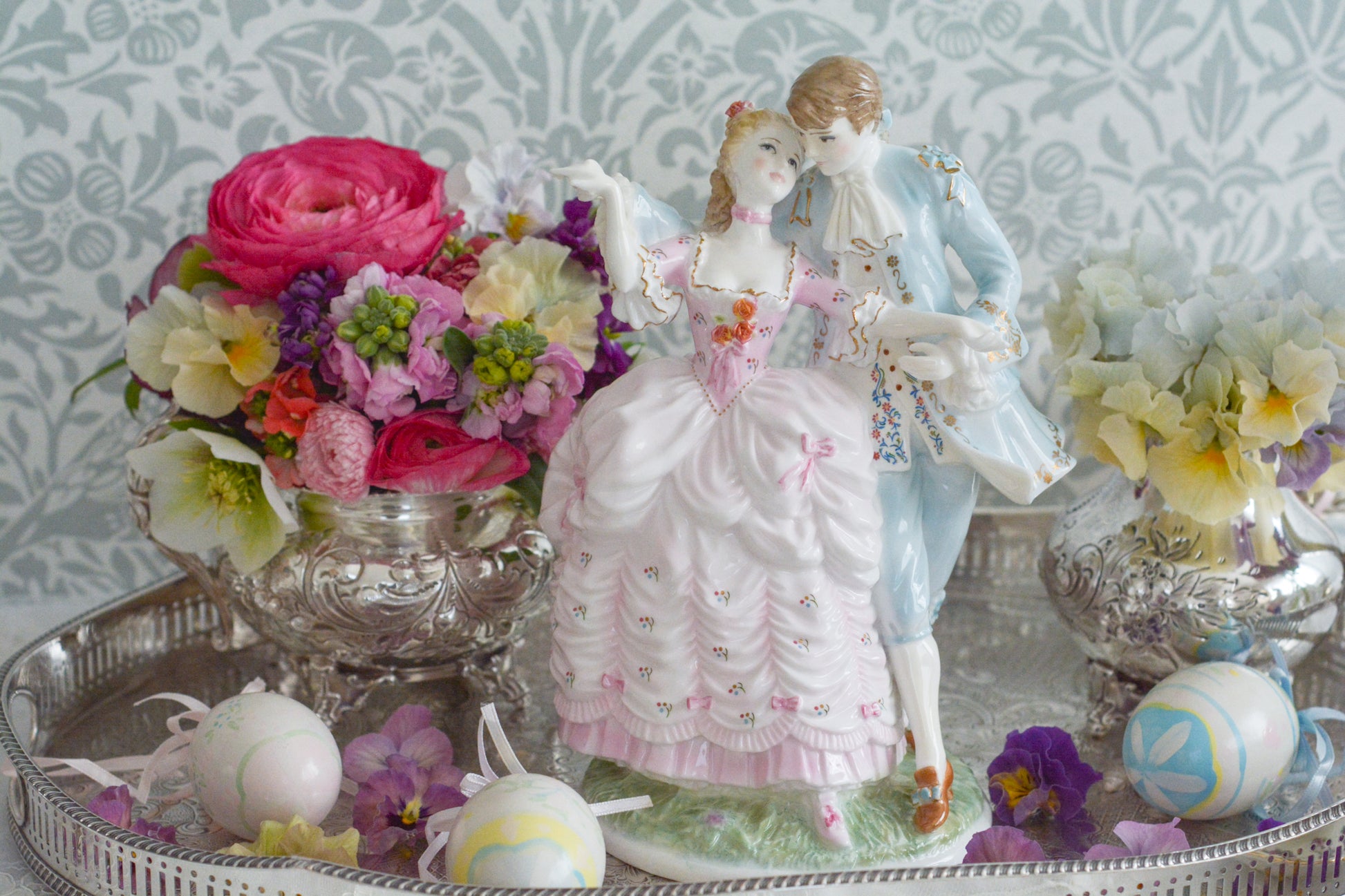 ロイヤルウースターの「AGE  OF CORTSHIP」シリーズの「The Flirtation」というフィギュリンです。「The Flirtation」「The Tryst」「The Betrothal」「The Proposal」があり、シリーズ名の通り、男女ペアのフィギュリンで構成されています。 寄り添ってダンスしているようにも見えます。 そしてパステルカラーの衣装の雰囲気やお顔の表情も柔らかく、初々しい様子も伝わってきます。2500体しか製造されていない大変貴重なフィギュリンです。