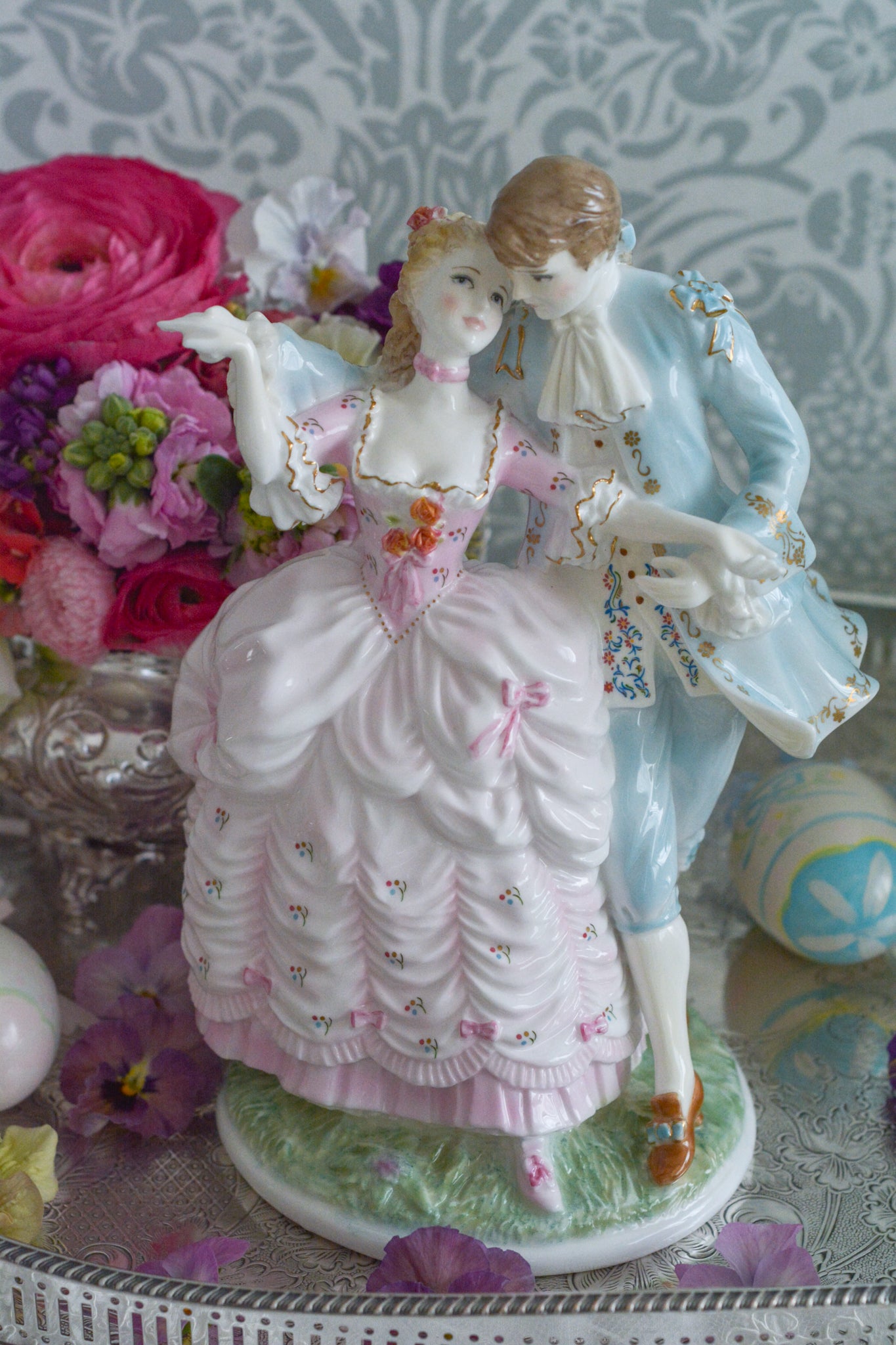 ロイヤルウースターの「AGE  OF CORTSHIP」シリーズの「The Flirtation」というフィギュリンです。「The Flirtation」「The Tryst」「The Betrothal」「The Proposal」があり、シリーズ名の通り、男女ペアのフィギュリンで構成されています。 寄り添ってダンスしているようにも見えます。 そしてパステルカラーの衣装の雰囲気やお顔の表情も柔らかく、初々しい様子も伝わってきます。2500体しか製造されていない大変貴重なフィギュリンです。