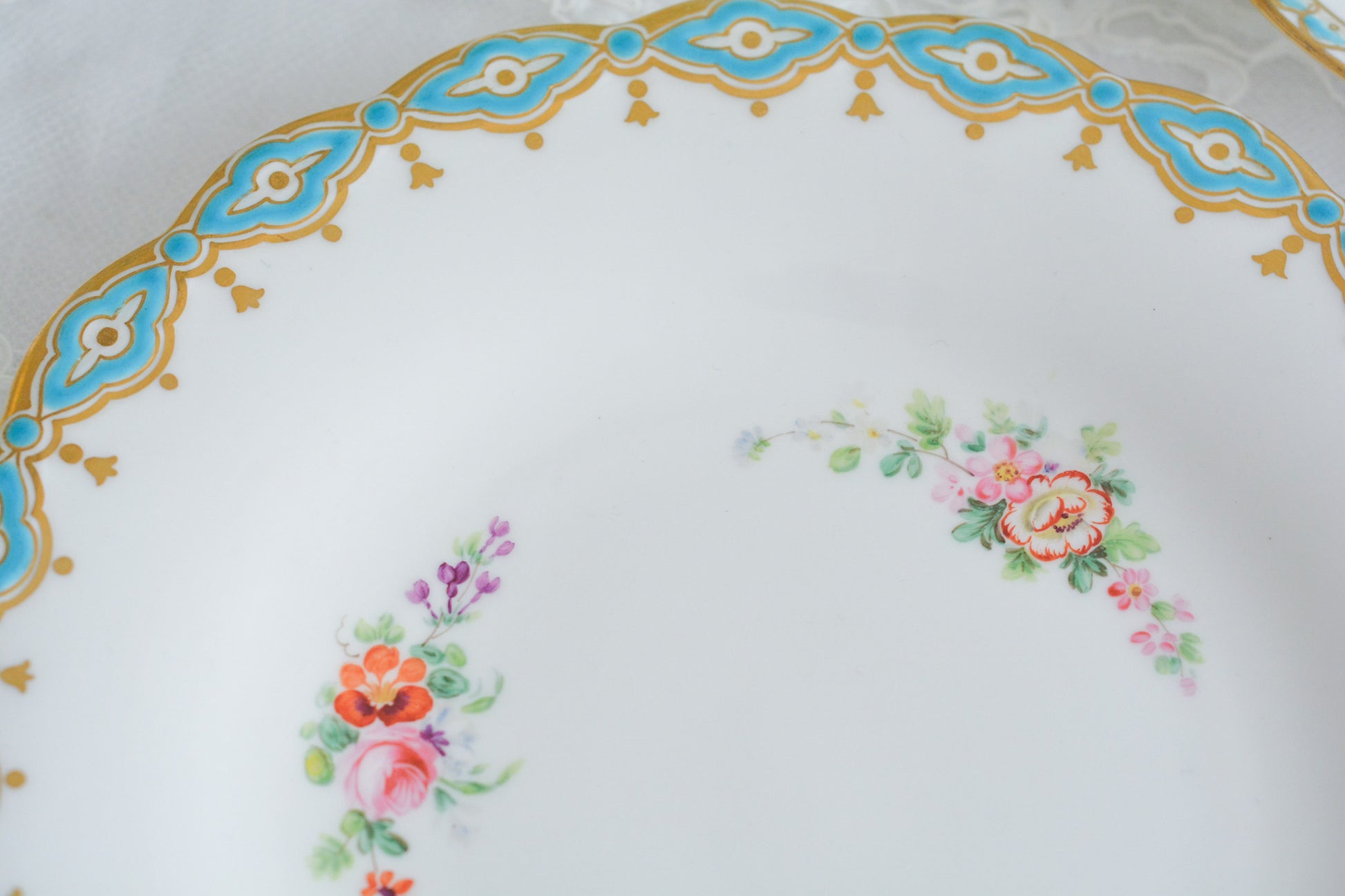 ミントンブルーが際立つ花々が美しいプレート。ハンドペイントで丁寧に描かれた花々が大変美しいです。縁に描かれたミントンブルーの模様がどんなものを盛り付けても引き立ててくれるデザインです