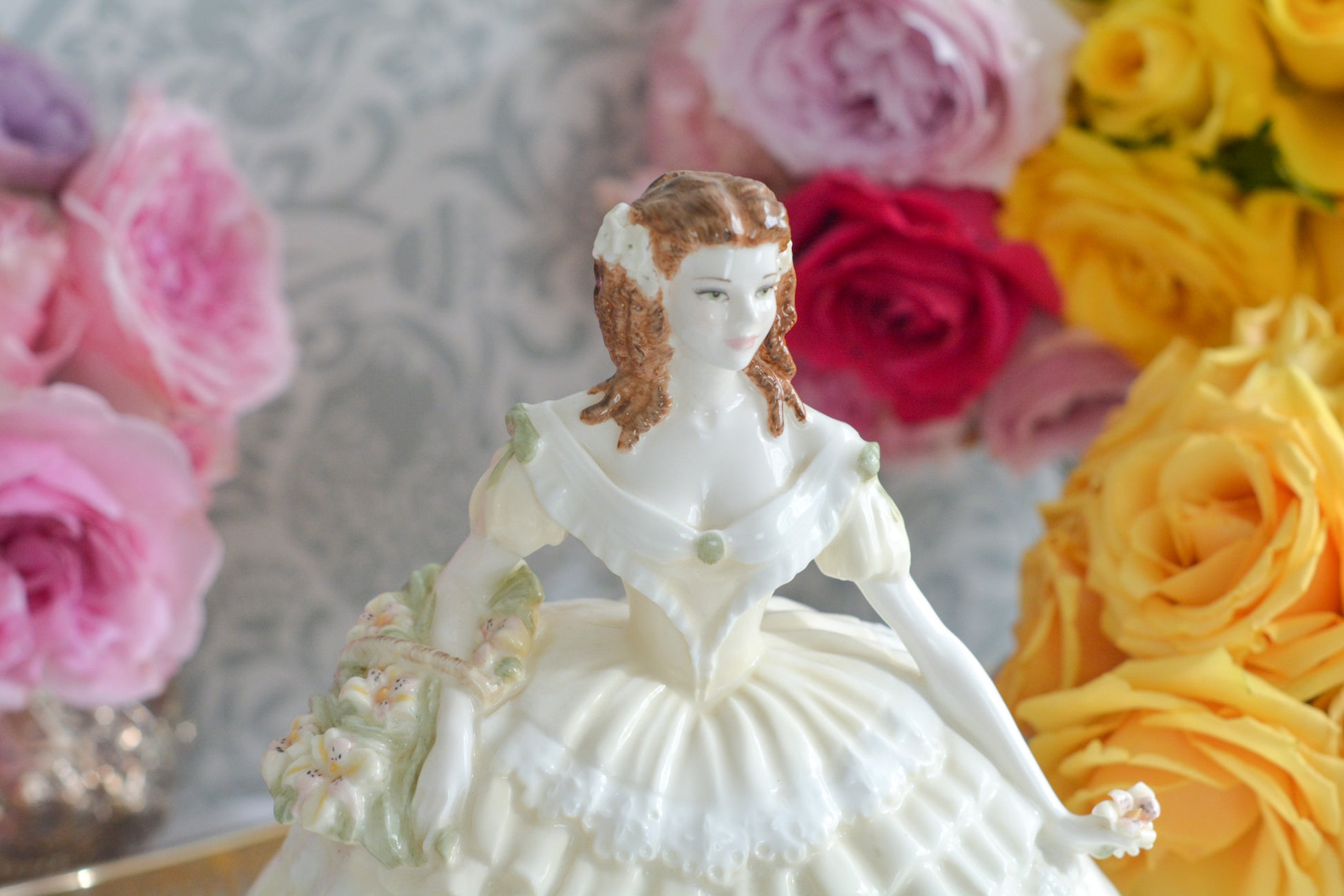 コールポートの人気フィギュリン、「The Four Flowers Collection」。名前の通り、「リリー、ローズ、カーネション、アイリス」の4つのお花がモチーフのフィギュリンシリーズです。 その中でも、リリーはアイリスと並び入手困難なお品です。  バスケットいっぱいのリリーと左手には一輪のリリーの花。ドレスはホワイトに淡いイエローのフリルとグリーンのリボンがあしらわれています。 柔らかな表情がとても可愛らしいレディのフィギュリンです。