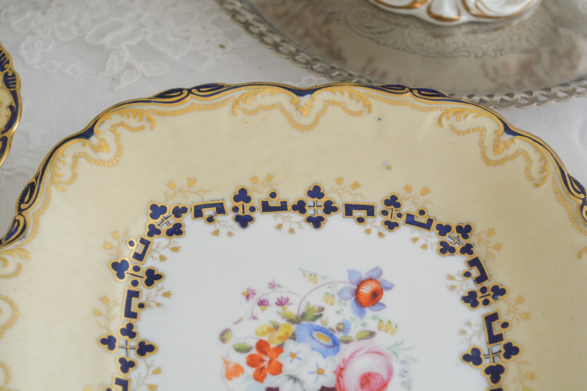 コールポートのアデレードシェイプのB&Bプレートです。ロココリバイバルの優雅なデザインが美しいです。ハンドペイントで描かれたブーケも大きく存在感もあり、ブーケを囲むコバルトブルーの模様もとっても可愛らしく、ブーケを引き立てています。B&Bとはブレッド&バターのことで、パンをもりつけたり、焼き菓子やフルーツなど様々な用途にお使いいただけます。テーブルがパッと華やかになるプレートです。