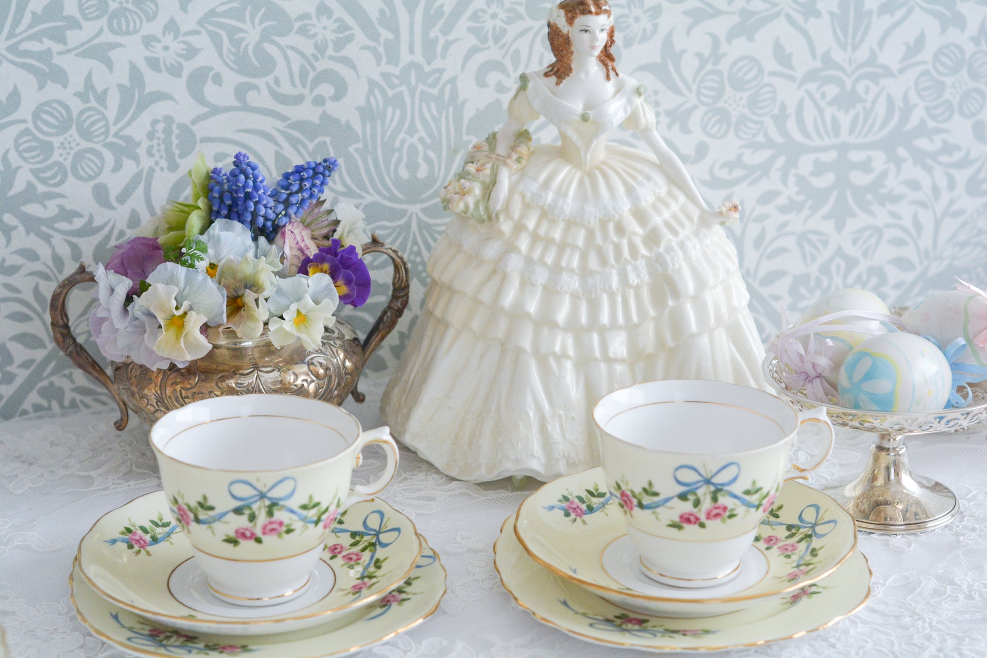コルクラフ(Colclough)の可愛らしいティートリオ。コルクラフは1890年にハーバード・ジョセフ・コルクラフ氏が創業したメーカで、1940年代頃まで続いていました。コルクラフの中でもこのリボンの絵柄は人気で入手困難なお品です。クリーム色にブルーリボンと小さなバラの模様がとっても可愛らしいデザインです。パステルカラーがイースターや春のティータイムにもぴったりですね!