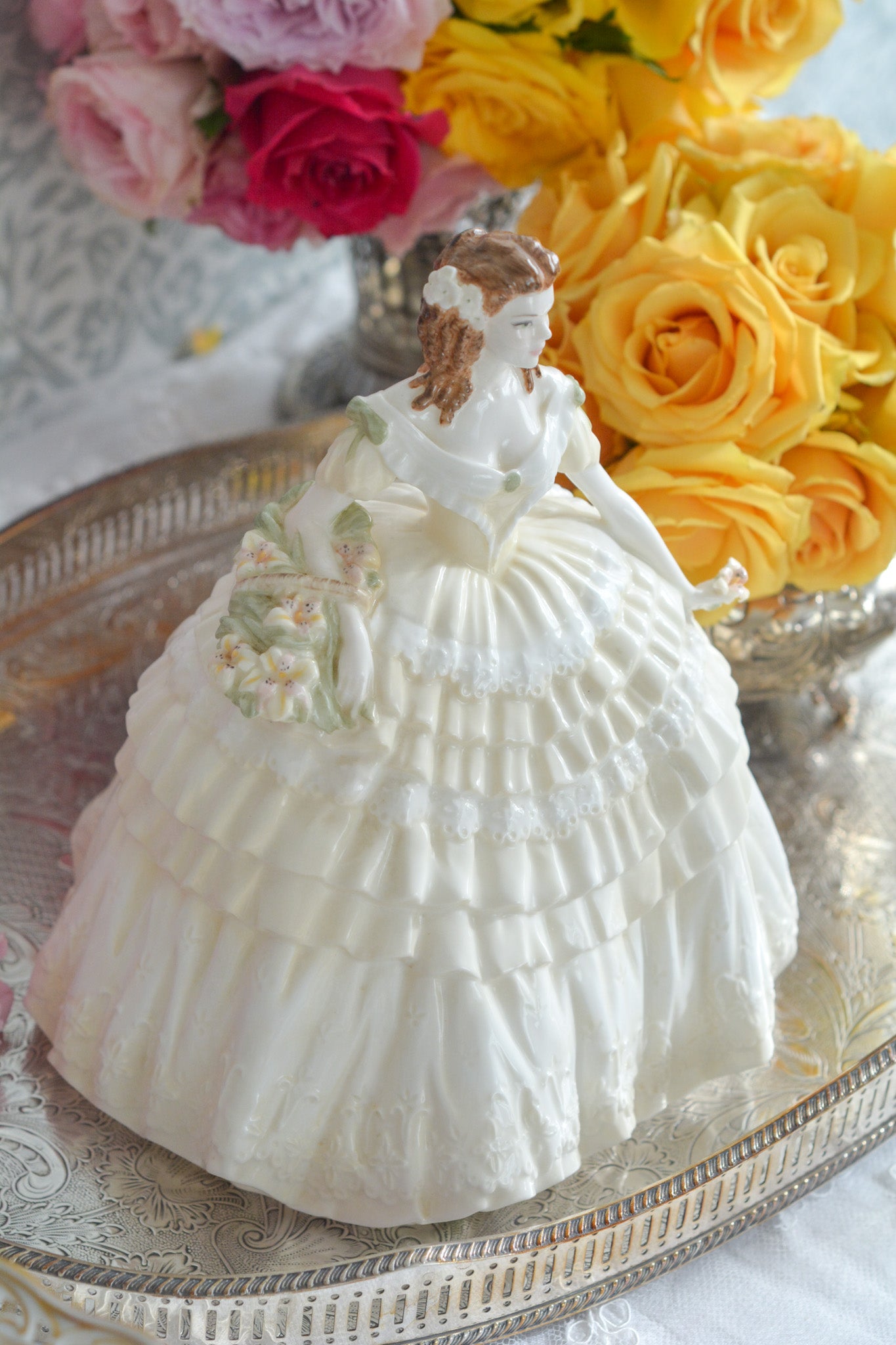 コールポートの人気フィギュリン、「The Four Flowers Collection」。名前の通り、「リリー、ローズ、カーネション、アイリス」の4つのお花がモチーフのフィギュリンシリーズです。 その中でも、リリーはアイリスと並び入手困難なお品です。  バスケットいっぱいのリリーと左手には一輪のリリーの花。ドレスはホワイトに淡いイエローのフリルとグリーンのリボンがあしらわれています。 柔らかな表情がとても可愛らしいレディのフィギュリンです。