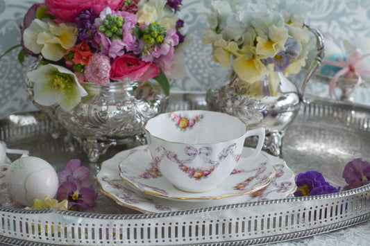 エインズレイのエレガントなティートリオ。リボンにバラーガーランドがとっても可愛らしく乙女心をくすぐられます。エンボスにハンドペイントで色つけされています。リボンのモチーフは人気ですが、アンティークでは数がとても少ないです。こちらのリボンは繊細なタッチに淡いカラーがとても美しく、エレガントな印象。素敵なあなたのためのティータイムにどうぞ。