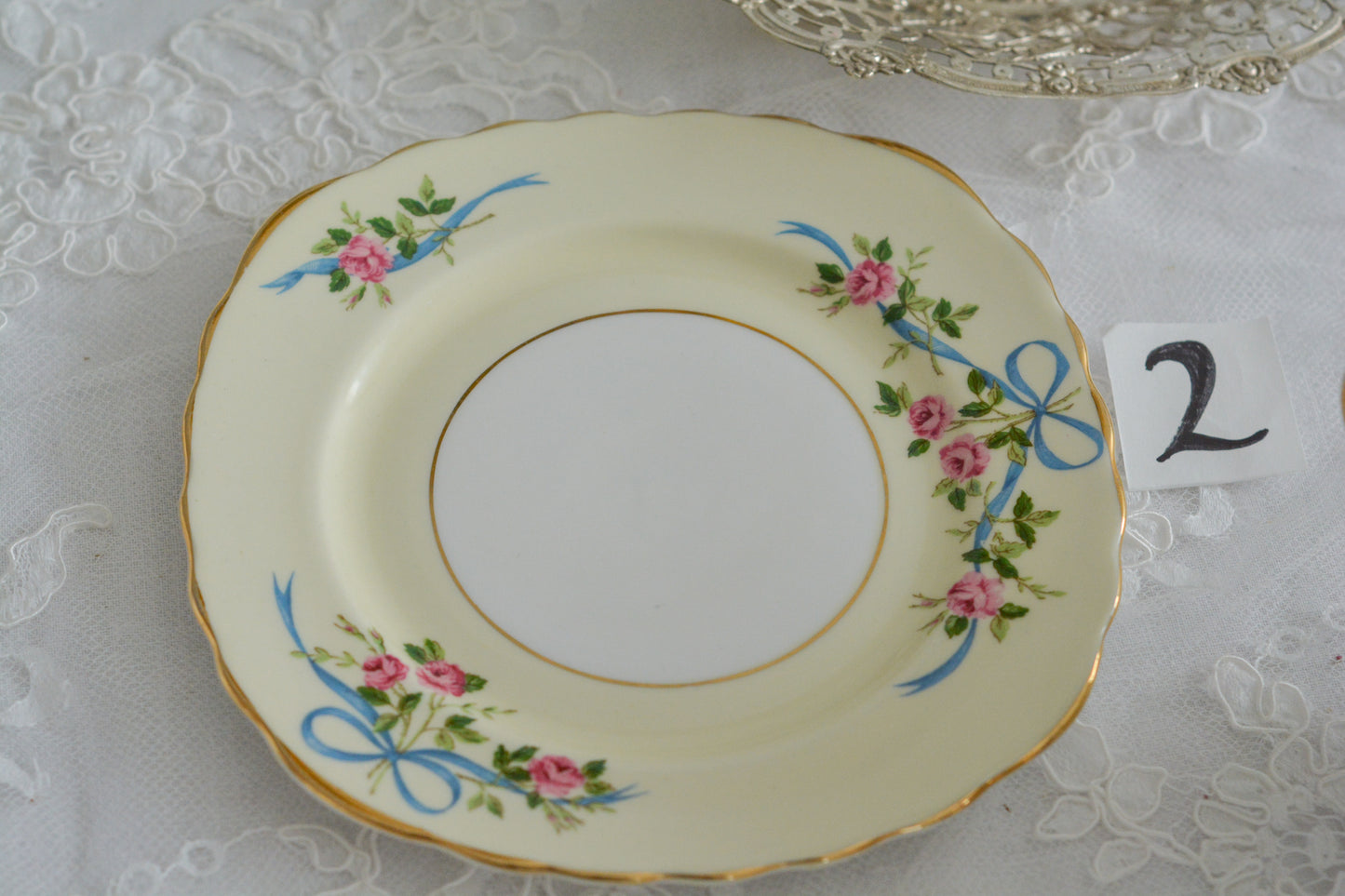 コルクラフ(Colclough)の可愛らしいティートリオ。コルクラフは1890年にハーバード・ジョセフ・コルクラフ氏が創業したメーカで、1940年代頃まで続いていました。コルクラフの中でもこのリボンの絵柄は人気で入手困難なお品です。クリーム色にブルーリボンと小さなバラの模様がとっても可愛らしいデザインです。パステルカラーがイースターや春のティータイムにもぴったりですね!