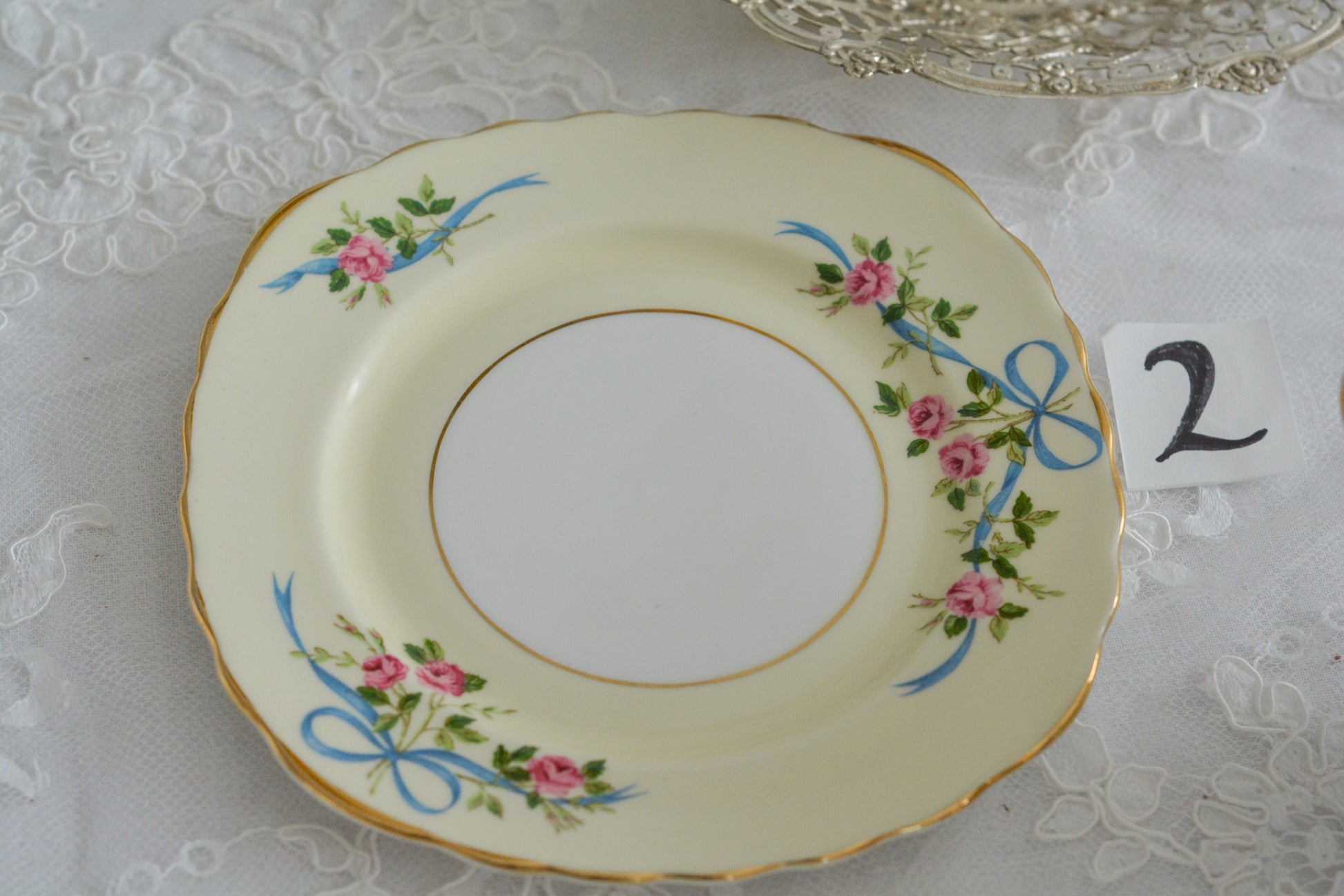 コルクラフ(Colclough)の可愛らしいティートリオ。コルクラフは1890年にハーバード・ジョセフ・コルクラフ氏が創業したメーカで、1940年代頃まで続いていました。コルクラフの中でもこのリボンの絵柄は人気で入手困難なお品です。クリーム色にブルーリボンと小さなバラの模様がとっても可愛らしいデザインです。パステルカラーがイースターや春のティータイムにもぴったりですね!