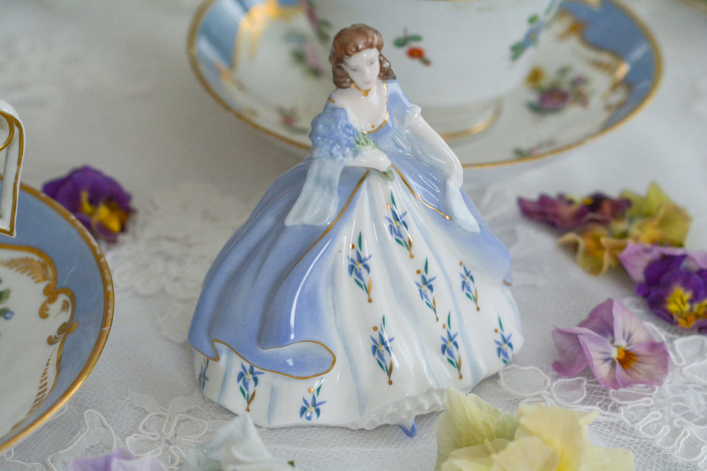 コールポートの小さなフィギュリン「IRIS」。アイリスのブーケを抱えてドレスにもアイリスのお花があしらわれています。優しげな表情も美しい。ミニサイズですが存在感があります。ティータイムにも使いやすいサイズ感も嬉しいですね。このお花のシリーズの小さなフィギュリンは何種類かあり、ついつい集めたくなってしまいます。