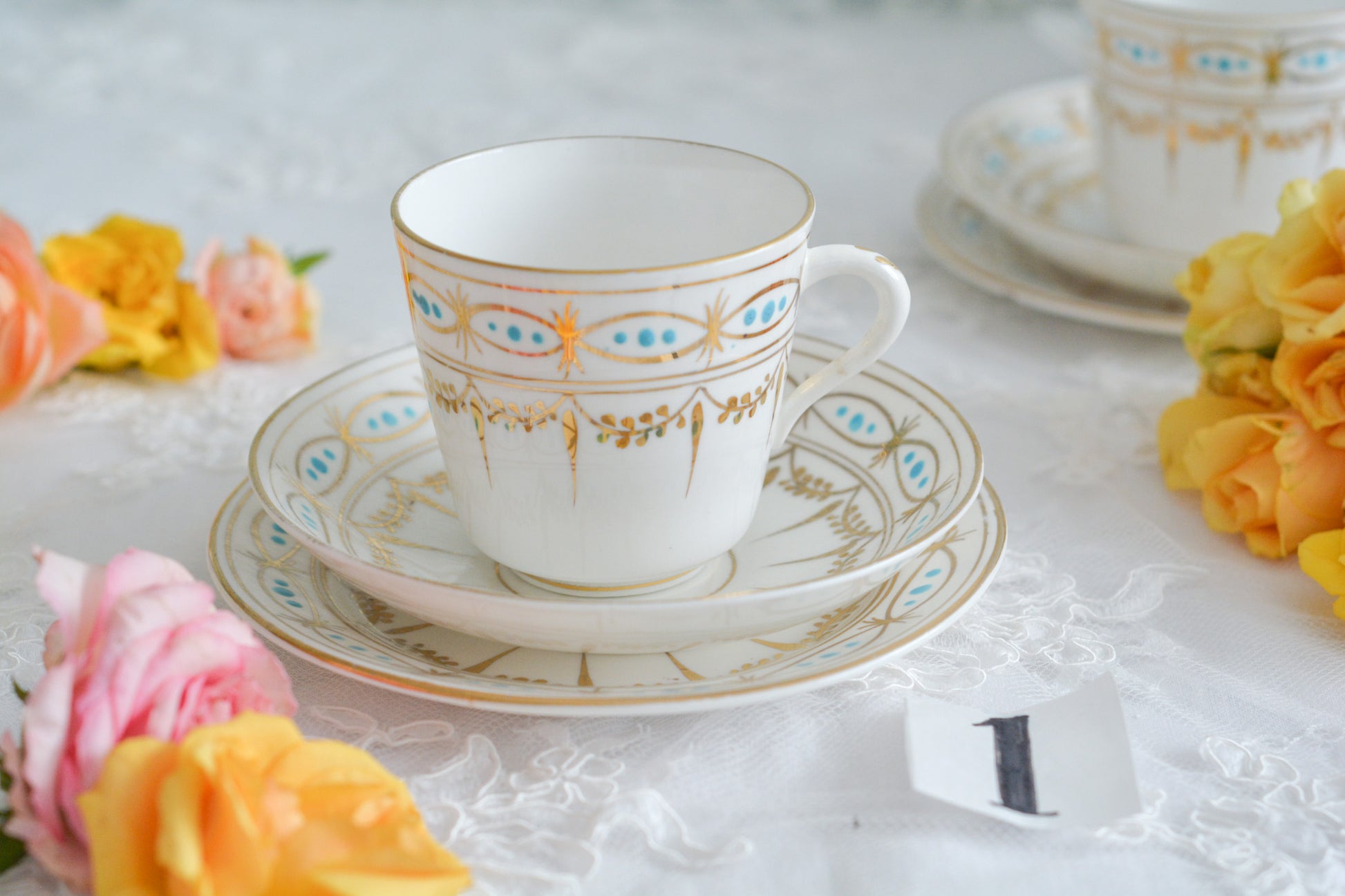 ハンドペイントで描かれた曲線美。アールヌーボースタイルのティートリオです。金彩にターコイズブルーのドットのコントラストが素敵なお品。カップは紅茶にもコーヒーにもお使いいただきやすいデザインです。