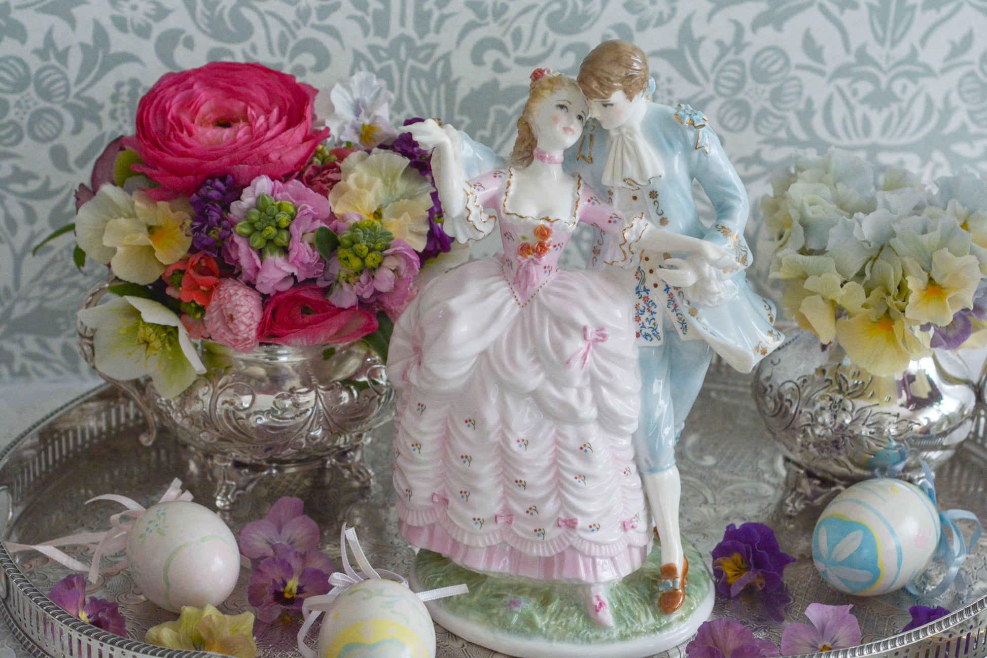 ロイヤルウースターの「AGE  OF CORTSHIP」シリーズの「The Flirtation」というフィギュリンです。「The Flirtation」「The Tryst」「The Betrothal」「The Proposal」があり、シリーズ名の通り、男女ペアのフィギュリンで構成されています。 寄り添ってダンスしているようにも見えます。 そしてパステルカラーの衣装の雰囲気やお顔の表情も柔らかく、初々しい様子も伝わってきます。2500体しか製造されていない大変貴重なフィギュリンです。