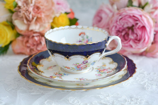 コールポートのコバルトブルーが美しいティートリオ。ねじれたデザインのハンドルに、ハンドペイントで絵付された上品な模様が大変美しいです。金彩の薄れとプレートの高台に欠けがありますが、貫入はありません。蚤の市企画のお品です。