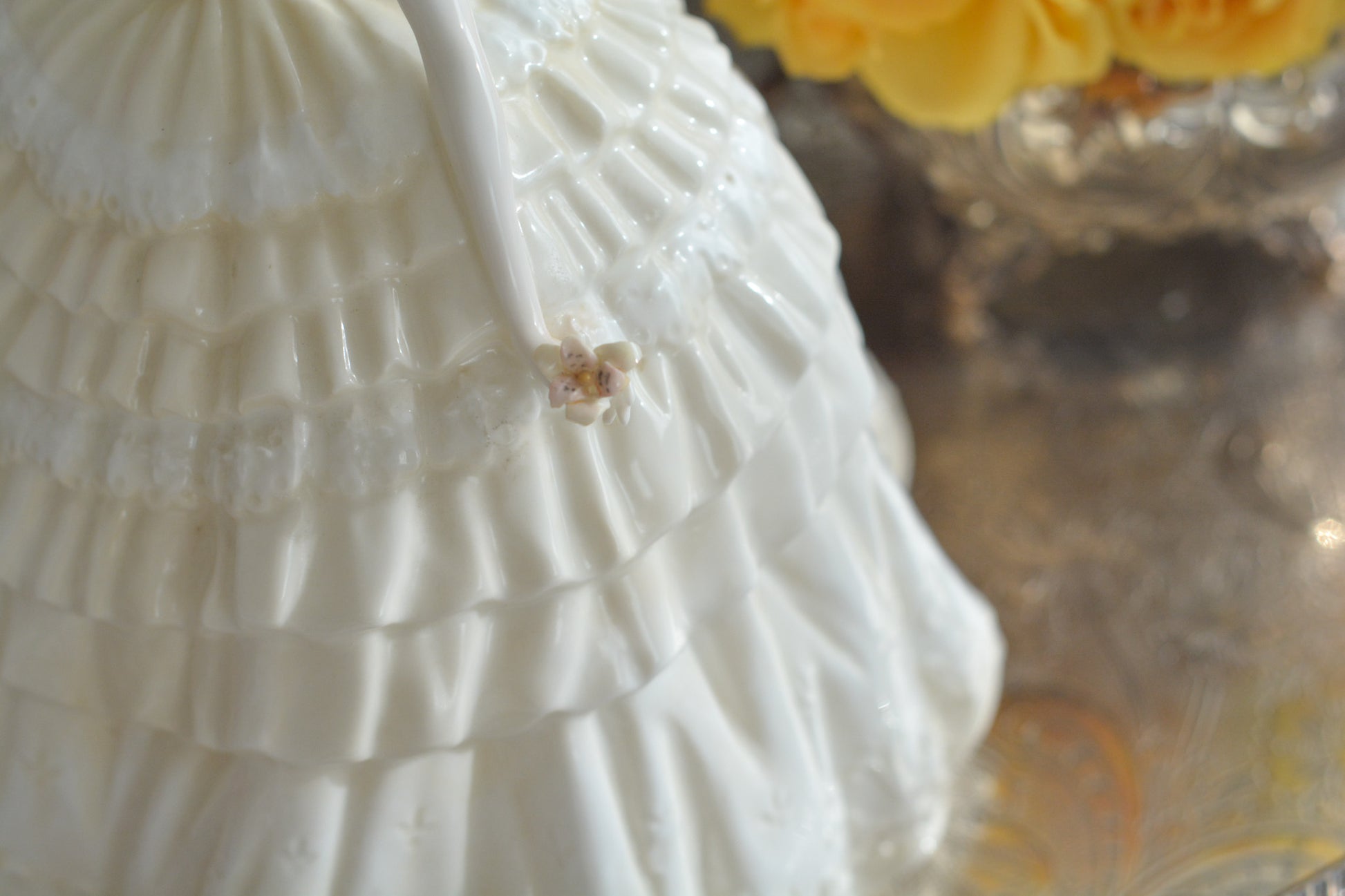 コールポートの人気フィギュリン、「The Four Flowers Collection」。名前の通り、「リリー、ローズ、カーネション、アイリス」の4つのお花がモチーフのフィギュリンシリーズです。 その中でも、リリーはアイリスと並び入手困難なお品です。  バスケットいっぱいのリリーと左手には一輪のリリーの花。ドレスはホワイトに淡いイエローのフリルとグリーンのリボンがあしらわれています。 柔らかな表情がとても可愛らしいレディのフィギュリンです。