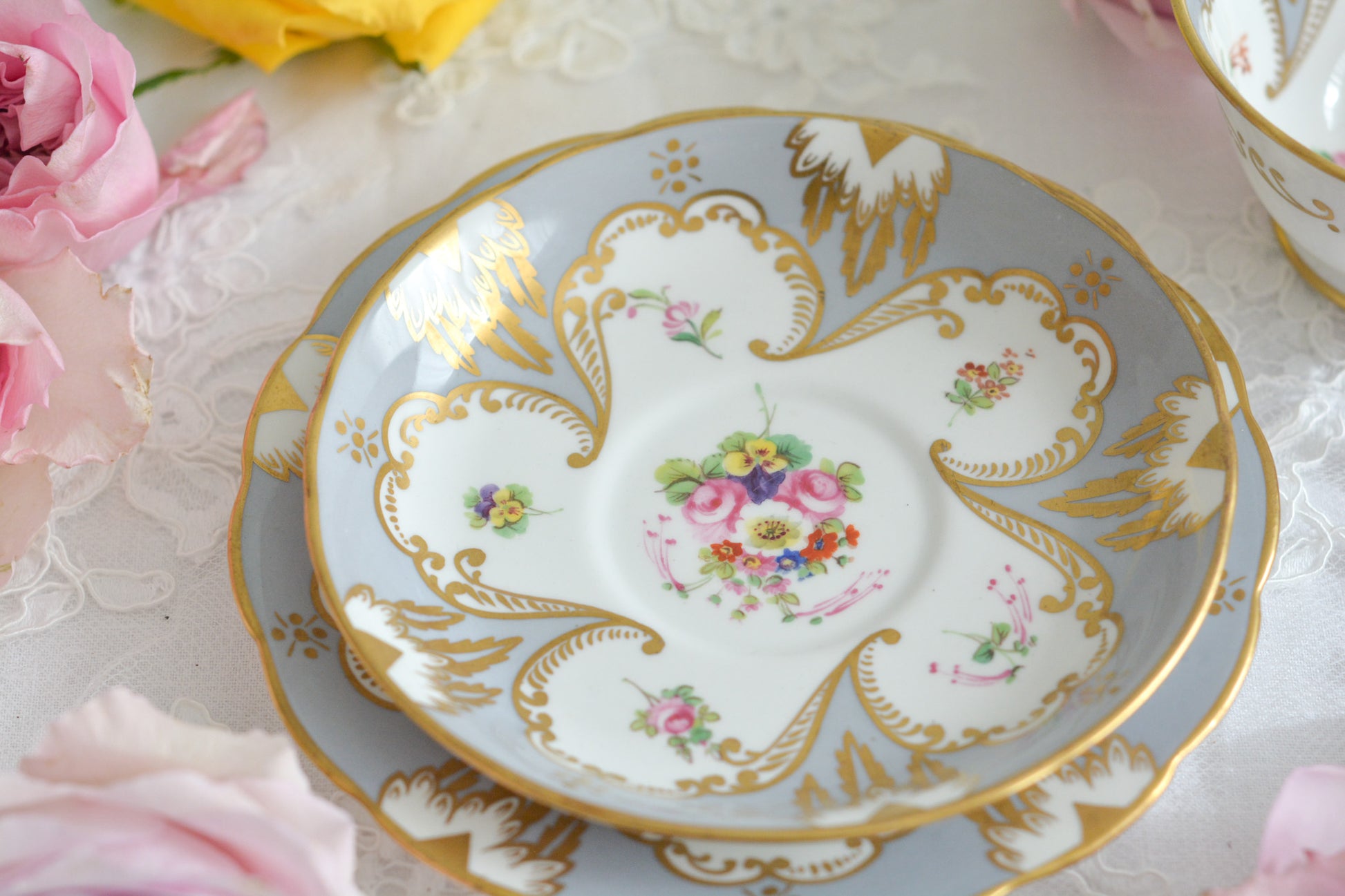 グレーカラーにハンドペイントで描かれた花々が美しいティートリオです。メーカーは不明ですが、以前ご紹介したハマースレイのアンティークトリオと雰囲気がよく似ています。金彩の模様もエレガントですね。残念ながらディーラーさんからの輸送時にカップにヒビが入ってしまいました。カップは観賞用となりますが、ソーサーとプレートはとても良い状態で、プレートのみお使いいただくこともできます。