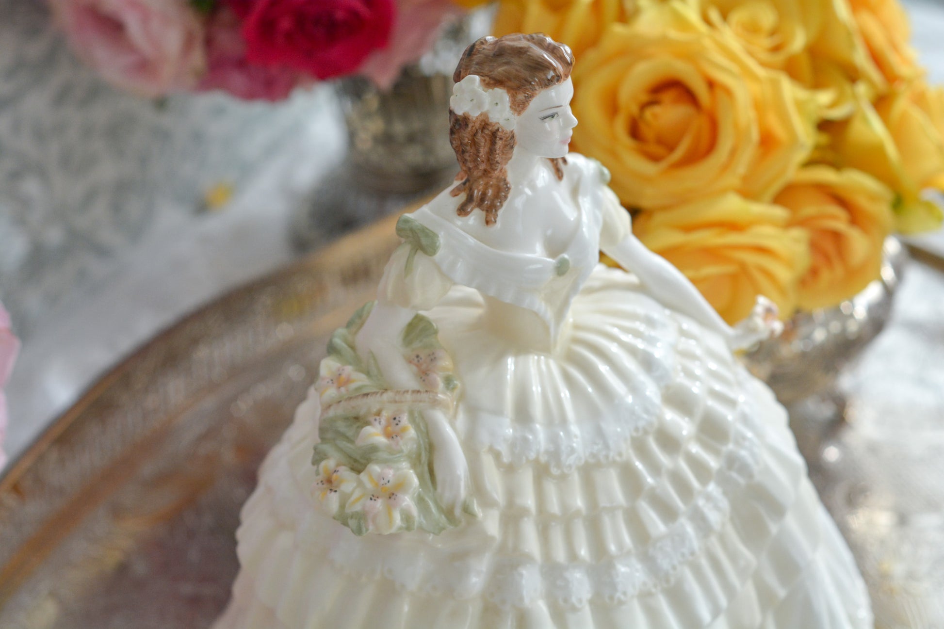 コールポートの人気フィギュリン、「The Four Flowers Collection」。名前の通り、「リリー、ローズ、カーネション、アイリス」の4つのお花がモチーフのフィギュリンシリーズです。 その中でも、リリーはアイリスと並び入手困難なお品です。  バスケットいっぱいのリリーと左手には一輪のリリーの花。ドレスはホワイトに淡いイエローのフリルとグリーンのリボンがあしらわれています。 柔らかな表情がとても可愛らしいレディのフィギュリンです。