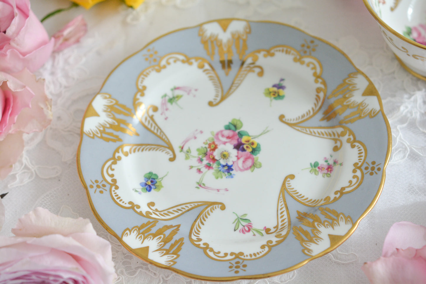 グレーカラーにハンドペイントで描かれた花々が美しいティートリオです。メーカーは不明ですが、以前ご紹介したハマースレイのアンティークトリオと雰囲気がよく似ています。金彩の模様もエレガントですね。残念ながらディーラーさんからの輸送時にカップにヒビが入ってしまいました。カップは観賞用となりますが、ソーサーとプレートはとても良い状態で、プレートのみお使いいただくこともできます。