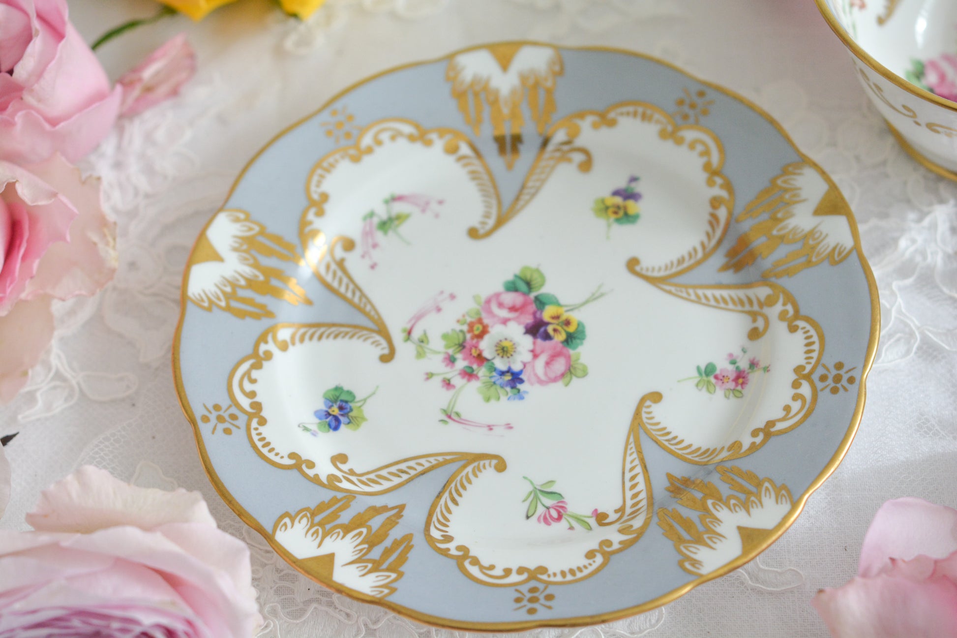 グレーカラーにハンドペイントで描かれた花々が美しいティートリオです。メーカーは不明ですが、以前ご紹介したハマースレイのアンティークトリオと雰囲気がよく似ています。金彩の模様もエレガントですね。残念ながらディーラーさんからの輸送時にカップにヒビが入ってしまいました。カップは観賞用となりますが、ソーサーとプレートはとても良い状態で、プレートのみお使いいただくこともできます。