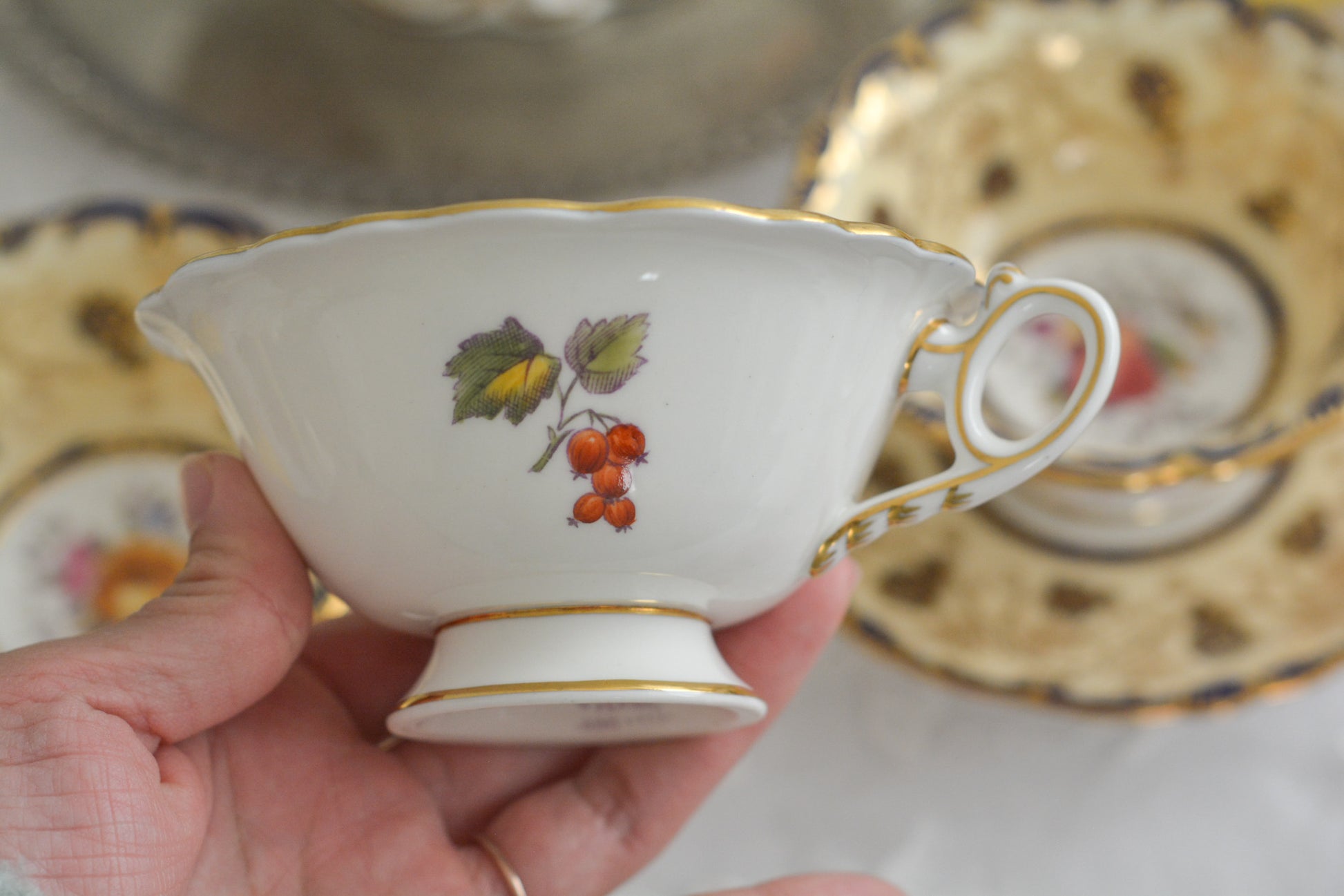 コールポートの1800年代の作品のリバイバルシリーズのオールドコールポートシリーズ。色々なお品がリバイバルされています。こちらはアデレードシェイプのリバイバル。ハンドルはアデレードシェイプハンドルではなくリングハンドルで、素磁も厚めに作られています。ロココリバイバルスタイルの優雅なデザインが美しいです。葡萄やフルーツ、お花の模様が大変豪華で美しいお品です。