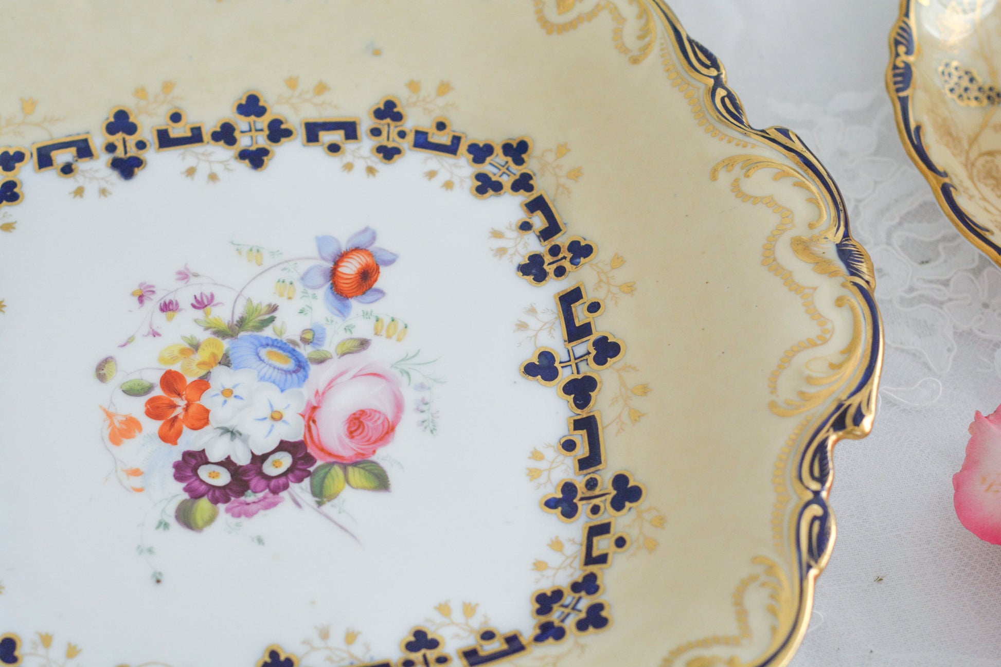 コールポートのアデレードシェイプのB&Bプレートです。ロココリバイバルの優雅なデザインが美しいです。ハンドペイントで描かれたブーケも大きく存在感もあり、ブーケを囲むコバルトブルーの模様もとっても可愛らしく、ブーケを引き立てています。B&Bとはブレッド&バターのことで、パンをもりつけたり、焼き菓子やフルーツなど様々な用途にお使いいただけます。テーブルがパッと華やかになるプレートです。