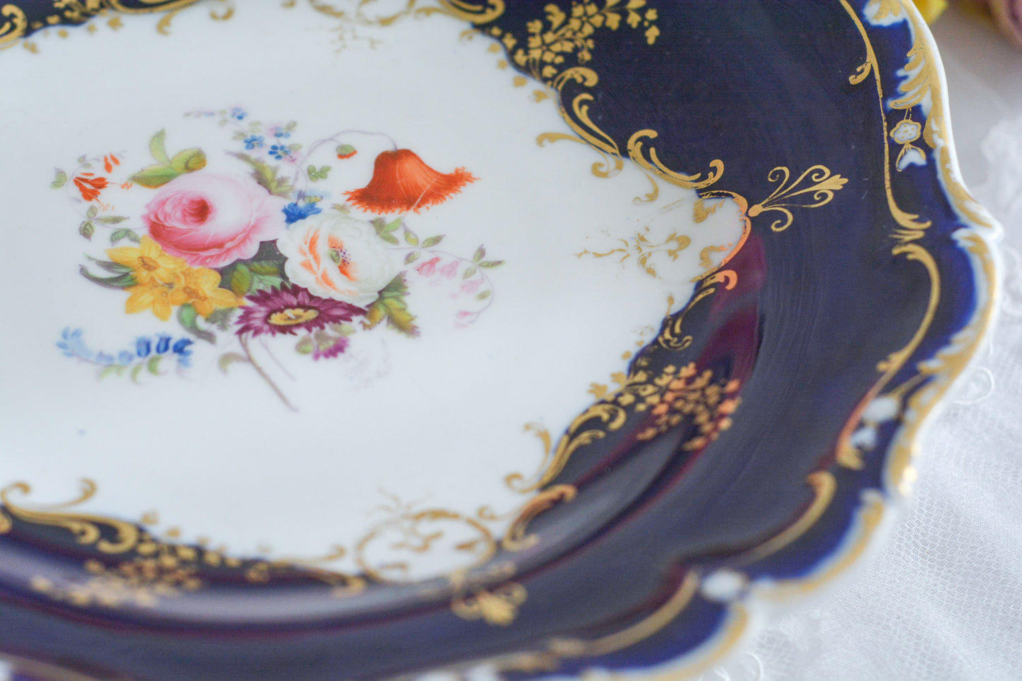 コバルトブルーカラーの美しいミントンのタッツァです。タッツァとはコンポートのような脚付きのプレートです。フルーツやお菓子を盛り付けるのにとても重宝するお品。美しいコバルトブルーカラーにハンドペイントのブーケがとても美しいです。あなたの大切なティータイムに是非お使いください