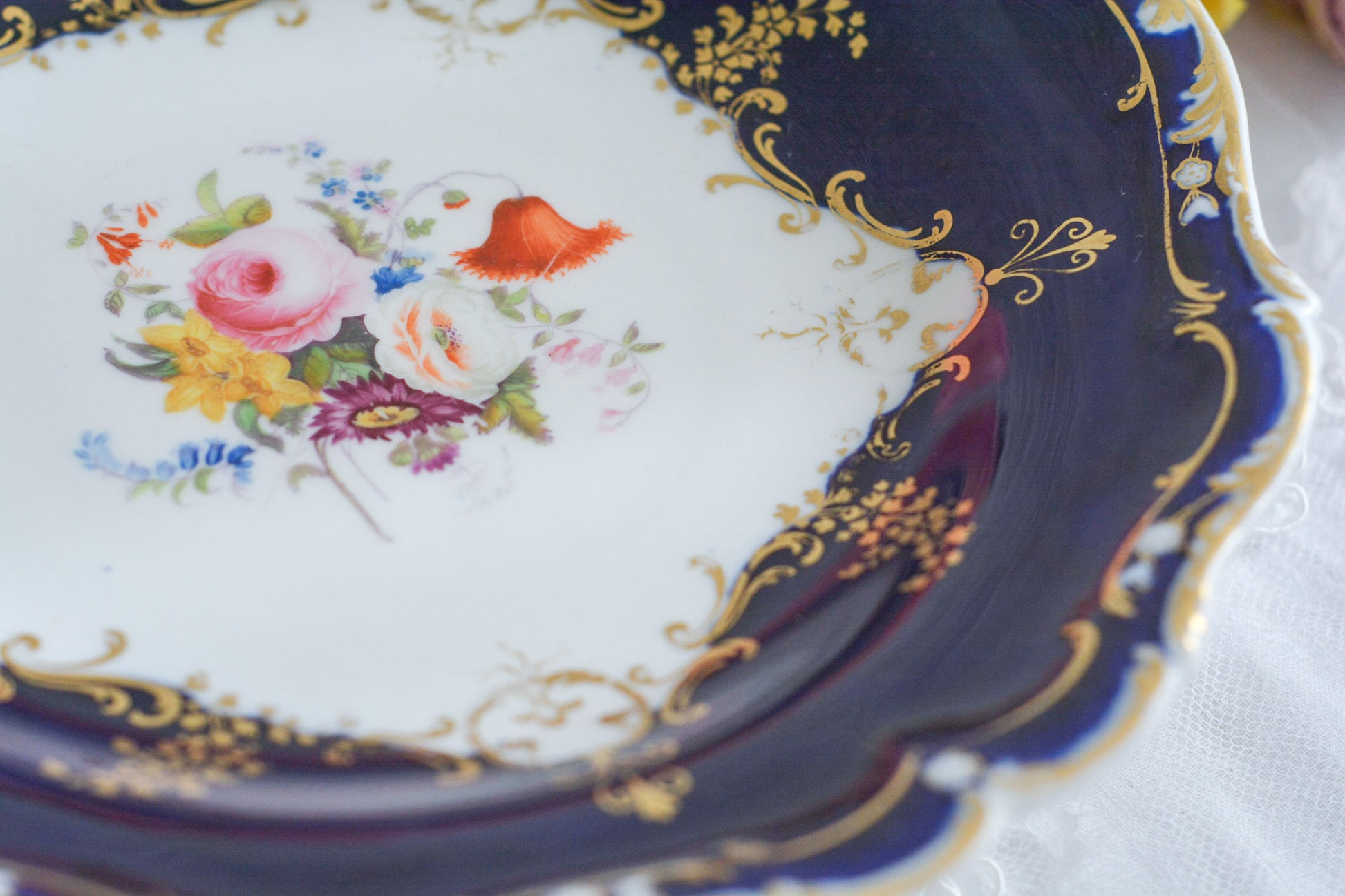 コバルトブルーカラーの美しいミントンのタッツァです。タッツァとはコンポートのような脚付きのプレートです。フルーツやお菓子を盛り付けるのにとても重宝するお品。美しいコバルトブルーカラーにハンドペイントのブーケがとても美しいです。あなたの大切なティータイムに是非お使いください