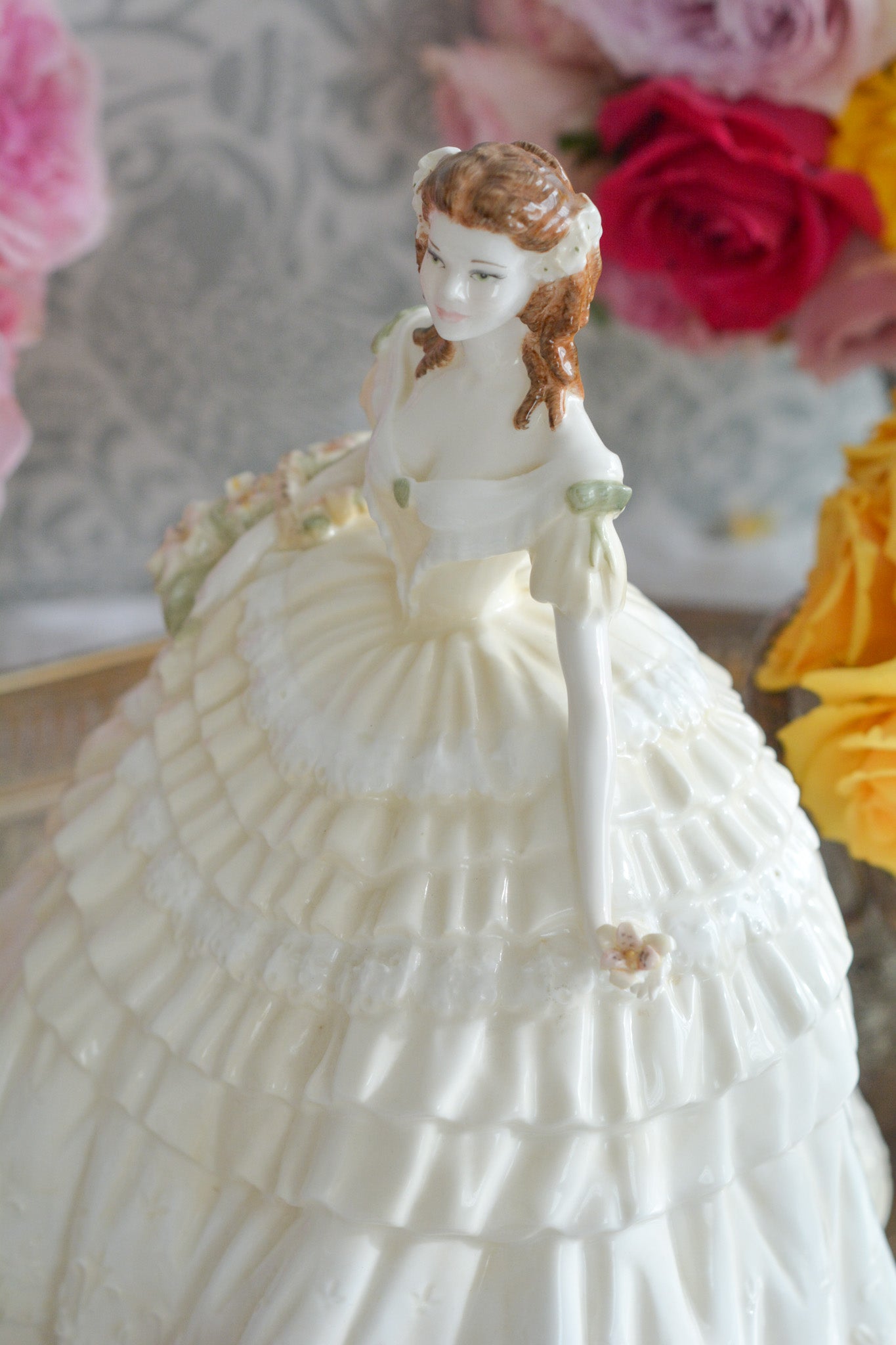 コールポートの人気フィギュリン、「The Four Flowers Collection」。名前の通り、「リリー、ローズ、カーネション、アイリス」の4つのお花がモチーフのフィギュリンシリーズです。 その中でも、リリーはアイリスと並び入手困難なお品です。  バスケットいっぱいのリリーと左手には一輪のリリーの花。ドレスはホワイトに淡いイエローのフリルとグリーンのリボンがあしらわれています。 柔らかな表情がとても可愛らしいレディのフィギュリンです。