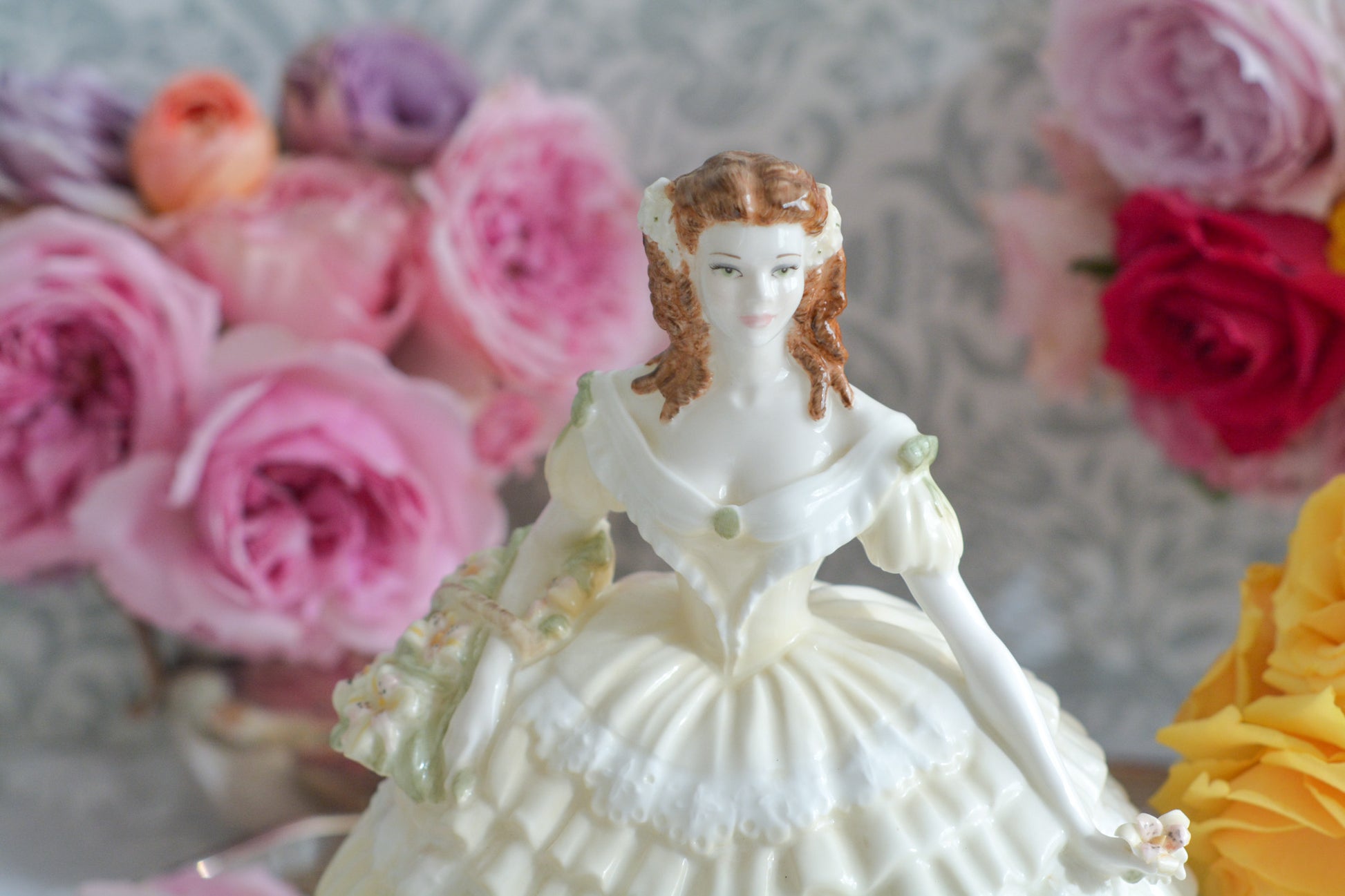 コールポートの人気フィギュリン、「The Four Flowers Collection」。名前の通り、「リリー、ローズ、カーネション、アイリス」の4つのお花がモチーフのフィギュリンシリーズです。 その中でも、リリーはアイリスと並び入手困難なお品です。  バスケットいっぱいのリリーと左手には一輪のリリーの花。ドレスはホワイトに淡いイエローのフリルとグリーンのリボンがあしらわれています。 柔らかな表情がとても可愛らしいレディのフィギュリンです。